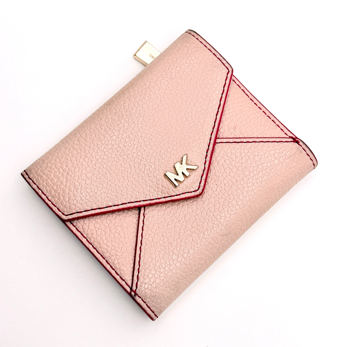 Michael Kors pink leather envelope trifold wallet with gold MK logo, shown closed on a white background.