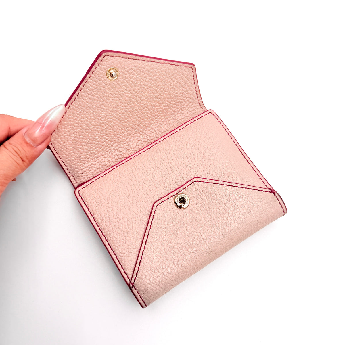 Michael Kors pink leather envelope trifold wallet with gold MK logo, shown closed on a white background.