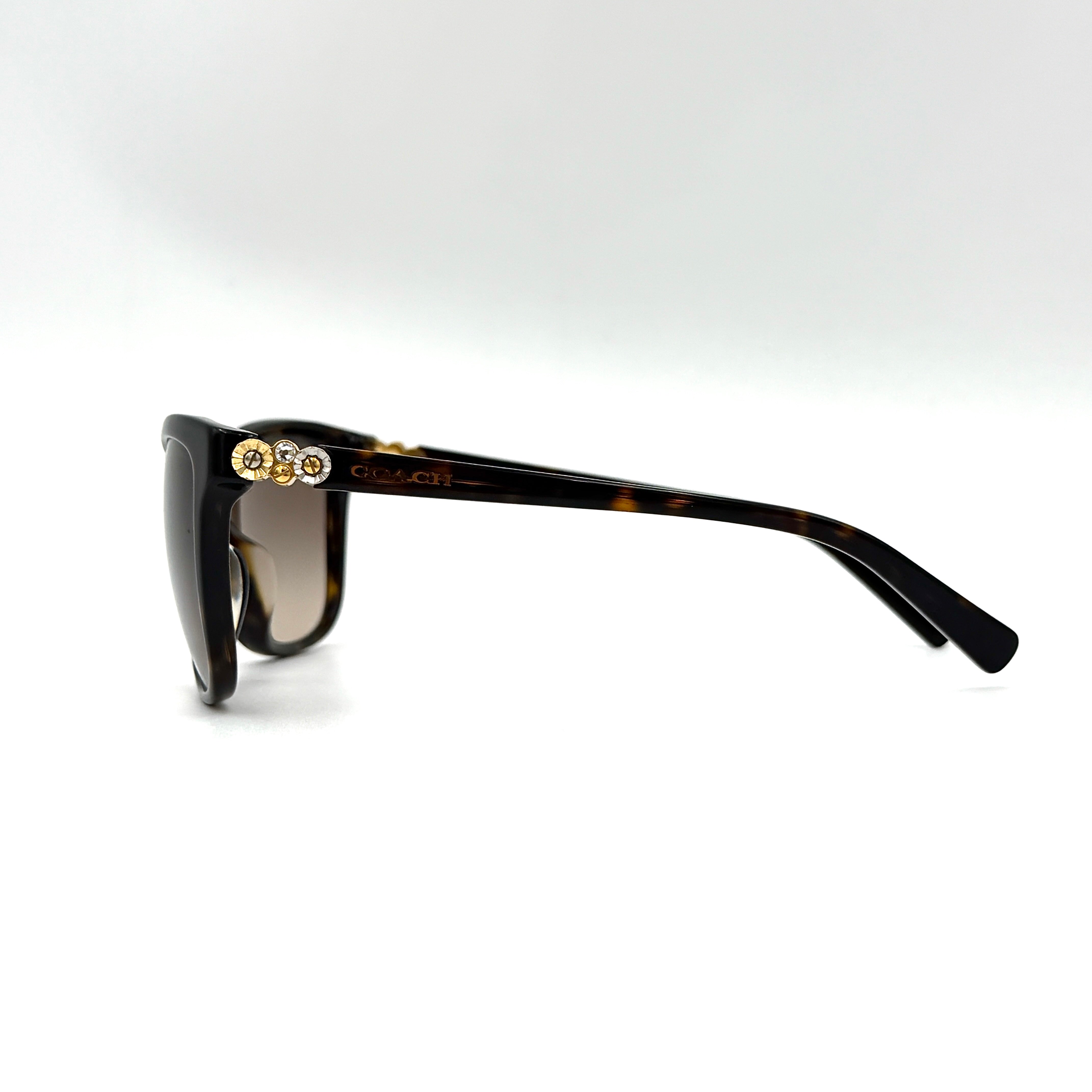 Coach HC8187BF sunglasses in dark tortoise acetate with gold floral and crystal temple detailing, shown in a three-quarter profile.