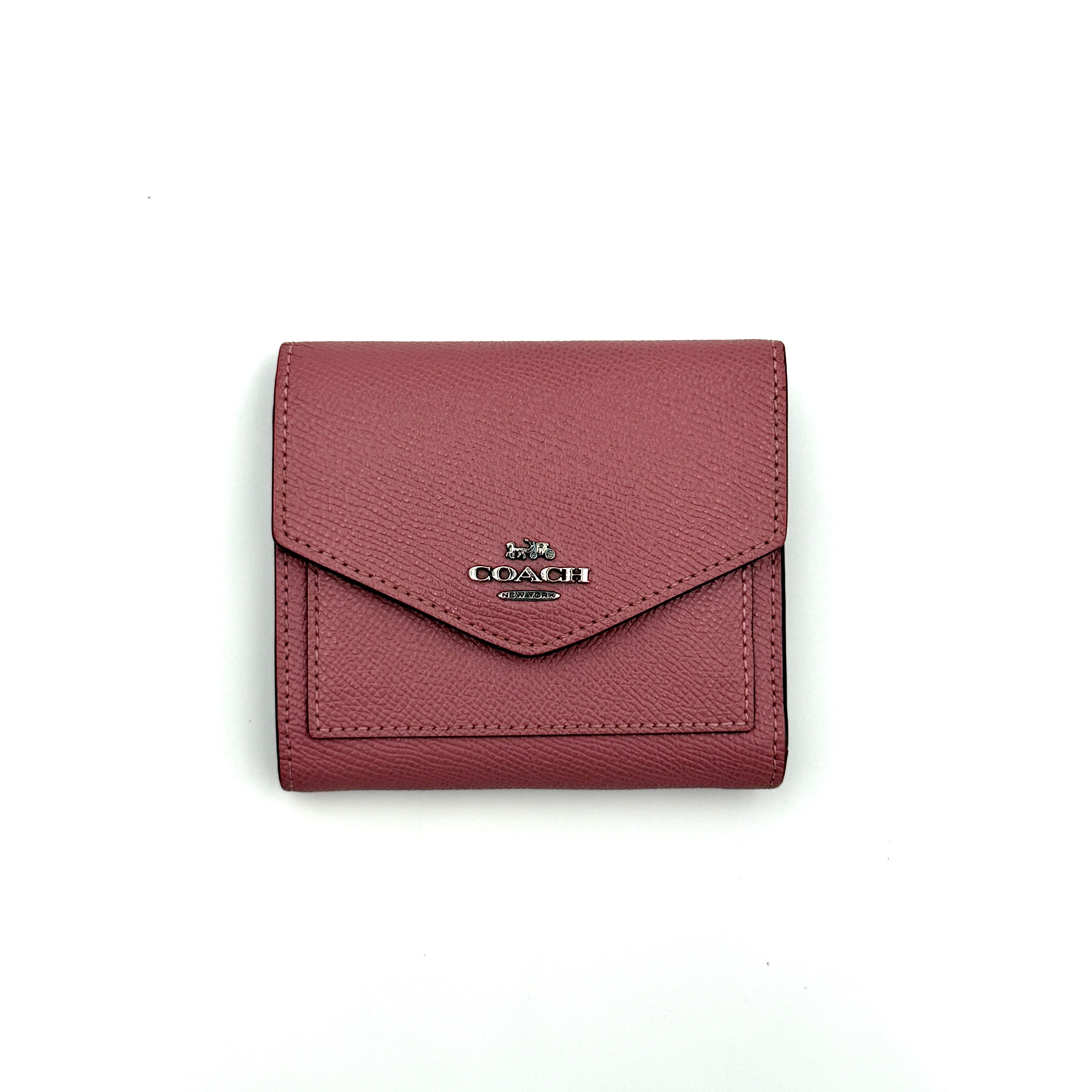 Coach Envelope Small Wallet in dusky pink grained leather with silver hardware and an angular flap closure.