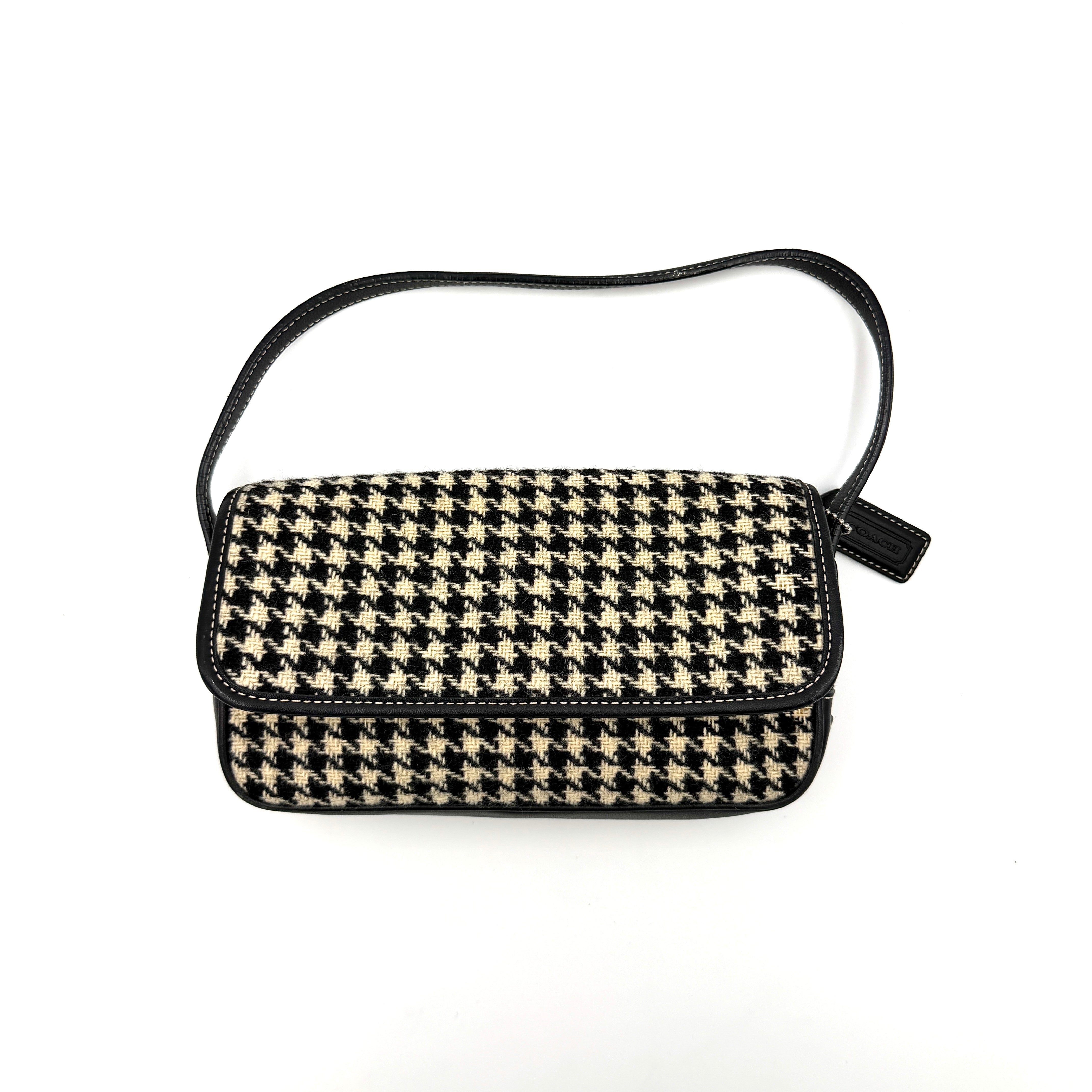 Coach Y2K shoulder bag with a bold black and cream houndstooth pattern and sleek leather trim.