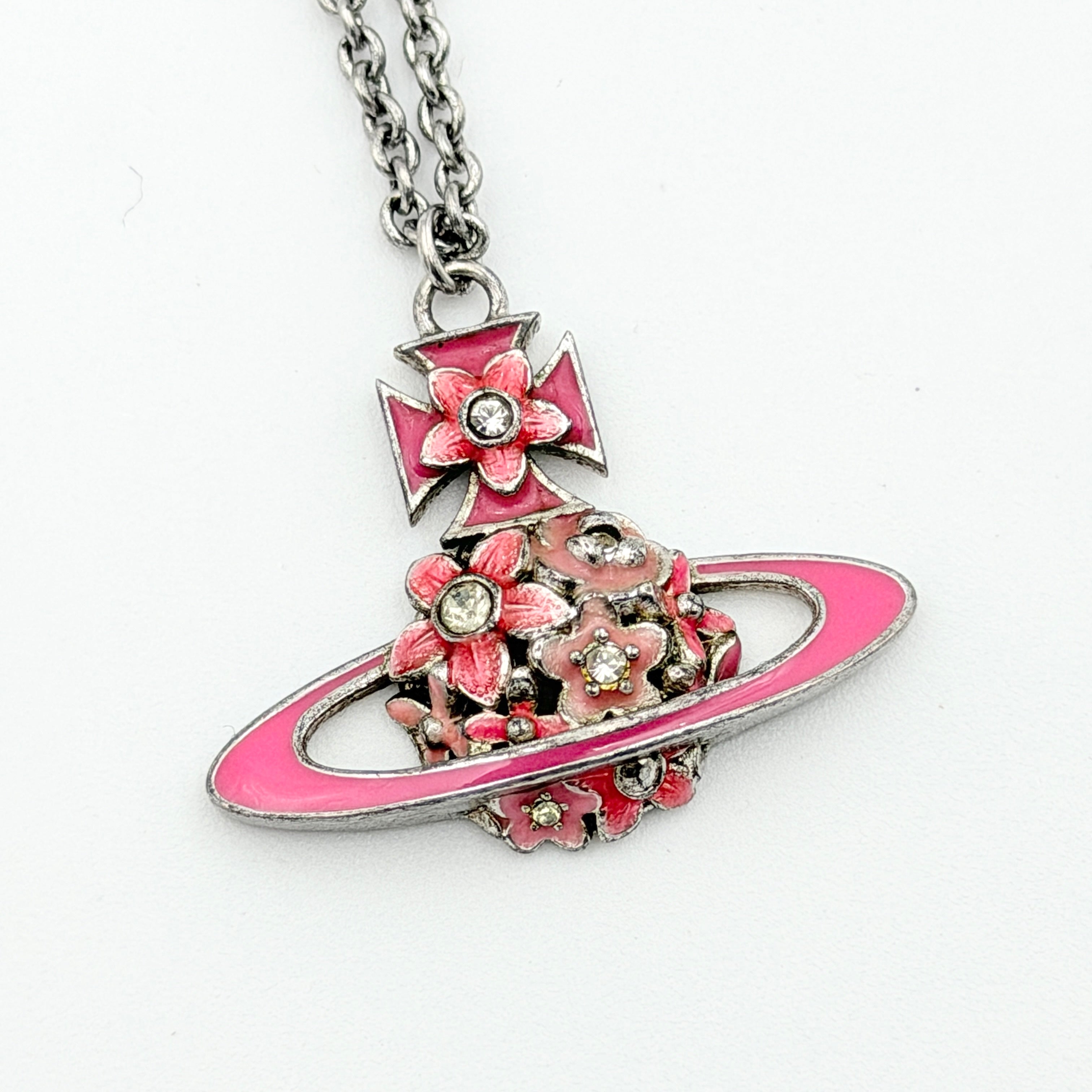 Vivienne Westwood Orb Flower Necklace in silver and pink displayed on a jewelry stand.