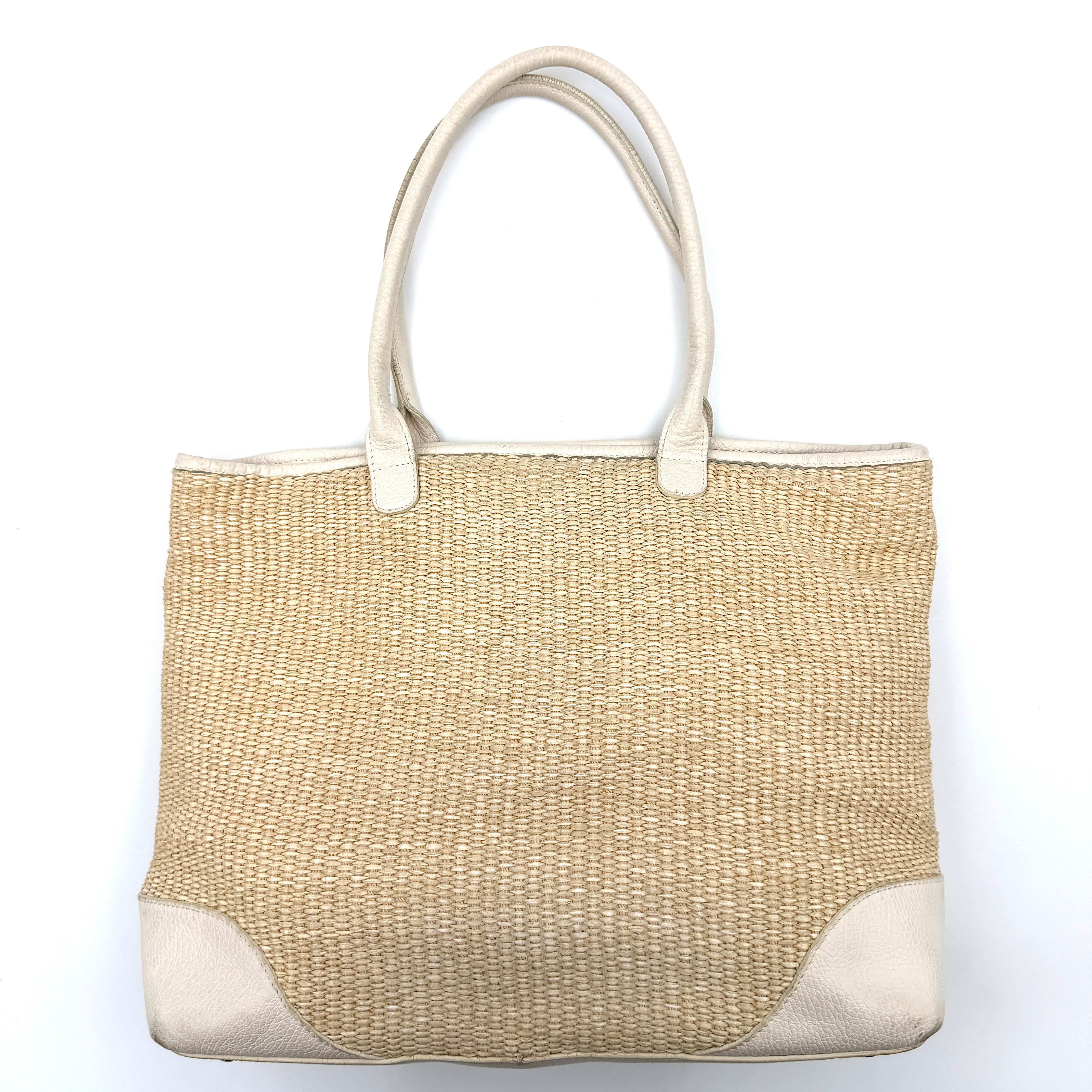 Furla beige woven straw tote bag with off-white leather handles and corners, featuring a silver oval logo plaque.