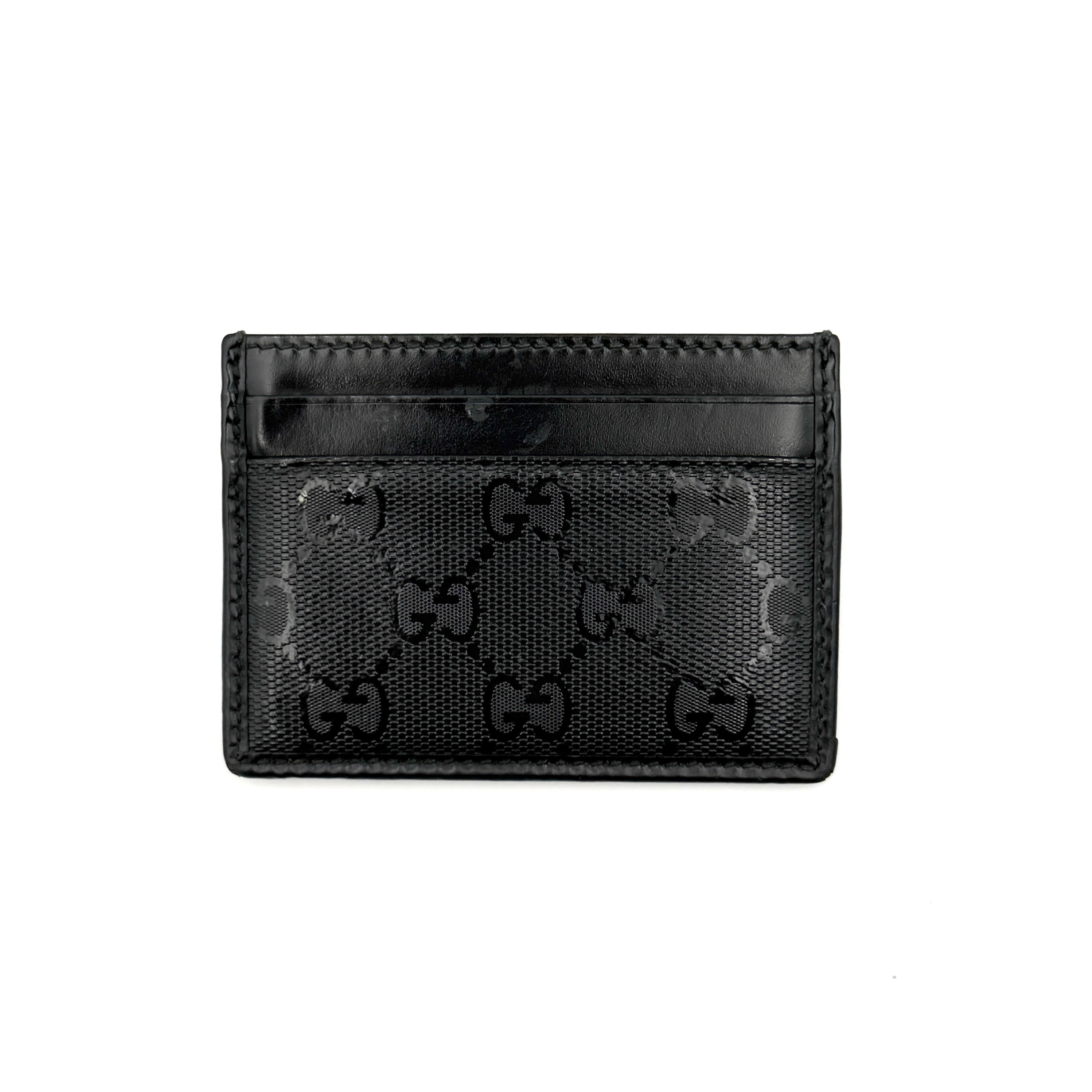Gucci GG Monogram card holder in black canvas and leather, featuring tonal logo pattern and four exterior card slots.