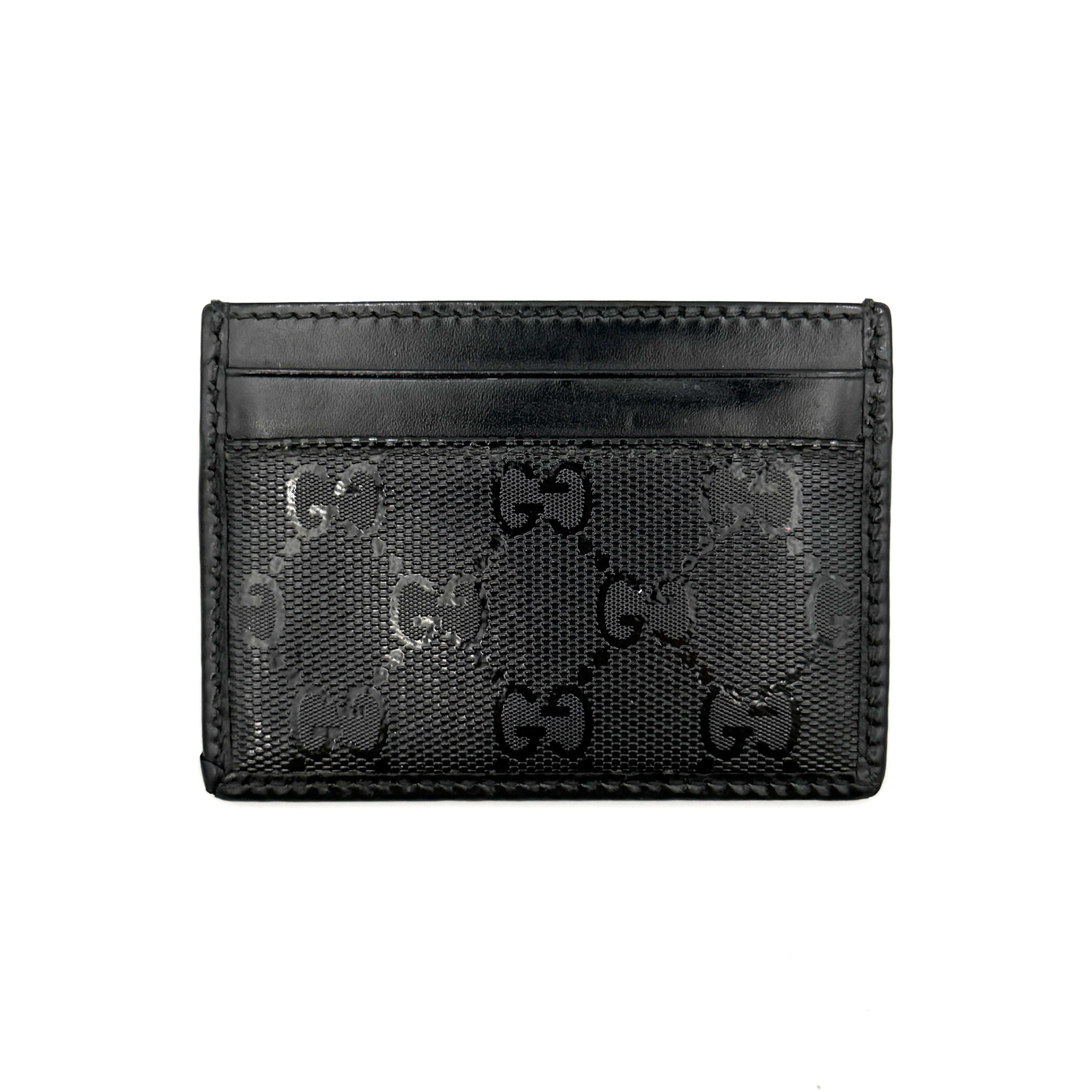 Gucci GG Monogram card holder in black canvas and leather, featuring tonal logo pattern and four exterior card slots.