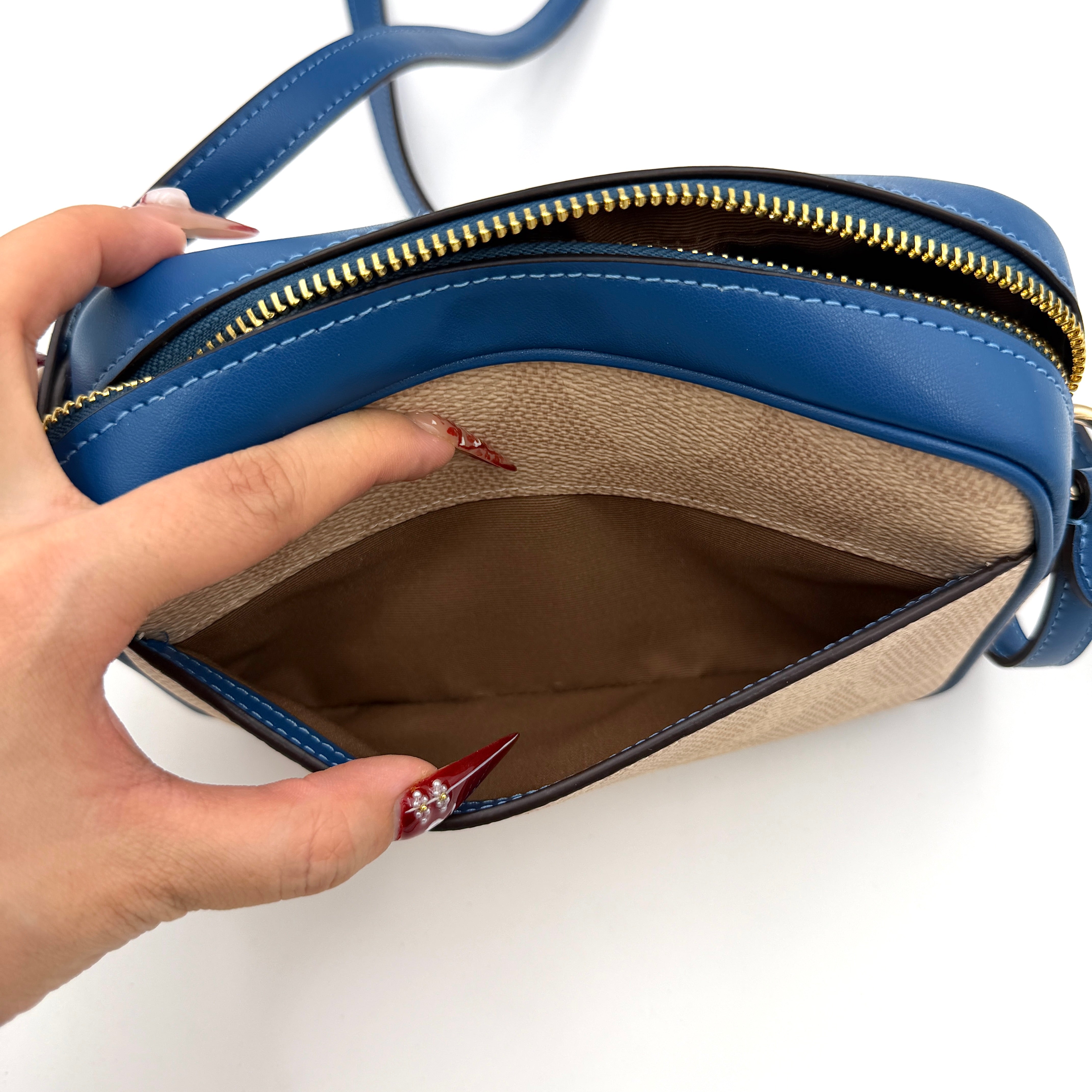 Coach Signature Jamie Camera Crossbody Bag in beige canvas with bold blue logo, cobalt trim, and adjustable blue leather strap.