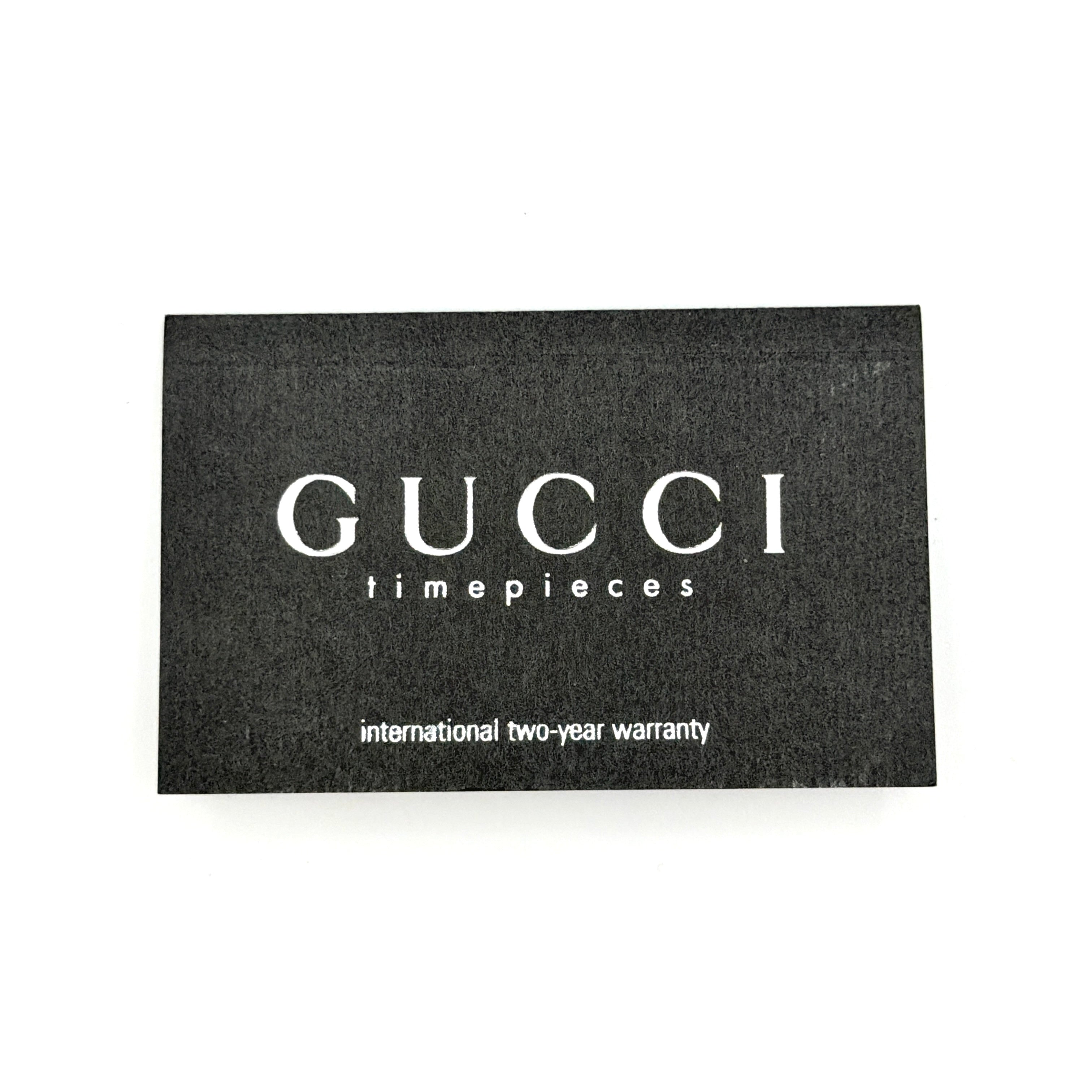 Gucci 1500L gold-tone quartz watch with white rectangular dial, displayed in box with warranty card.