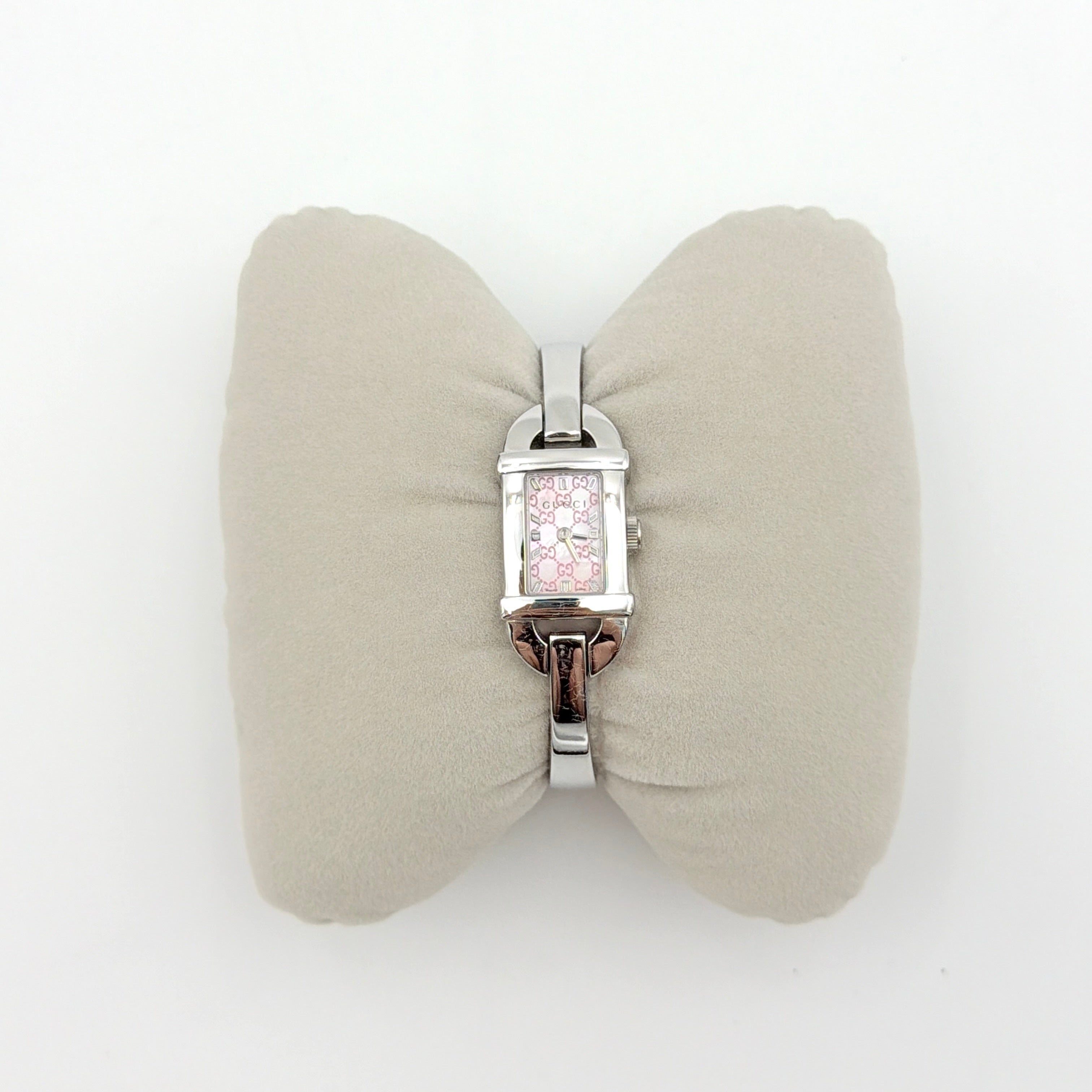 Gucci 6800L GG Bangle Watch in stainless steel with a pink monogram dial, displayed in its original box with branded booklet.