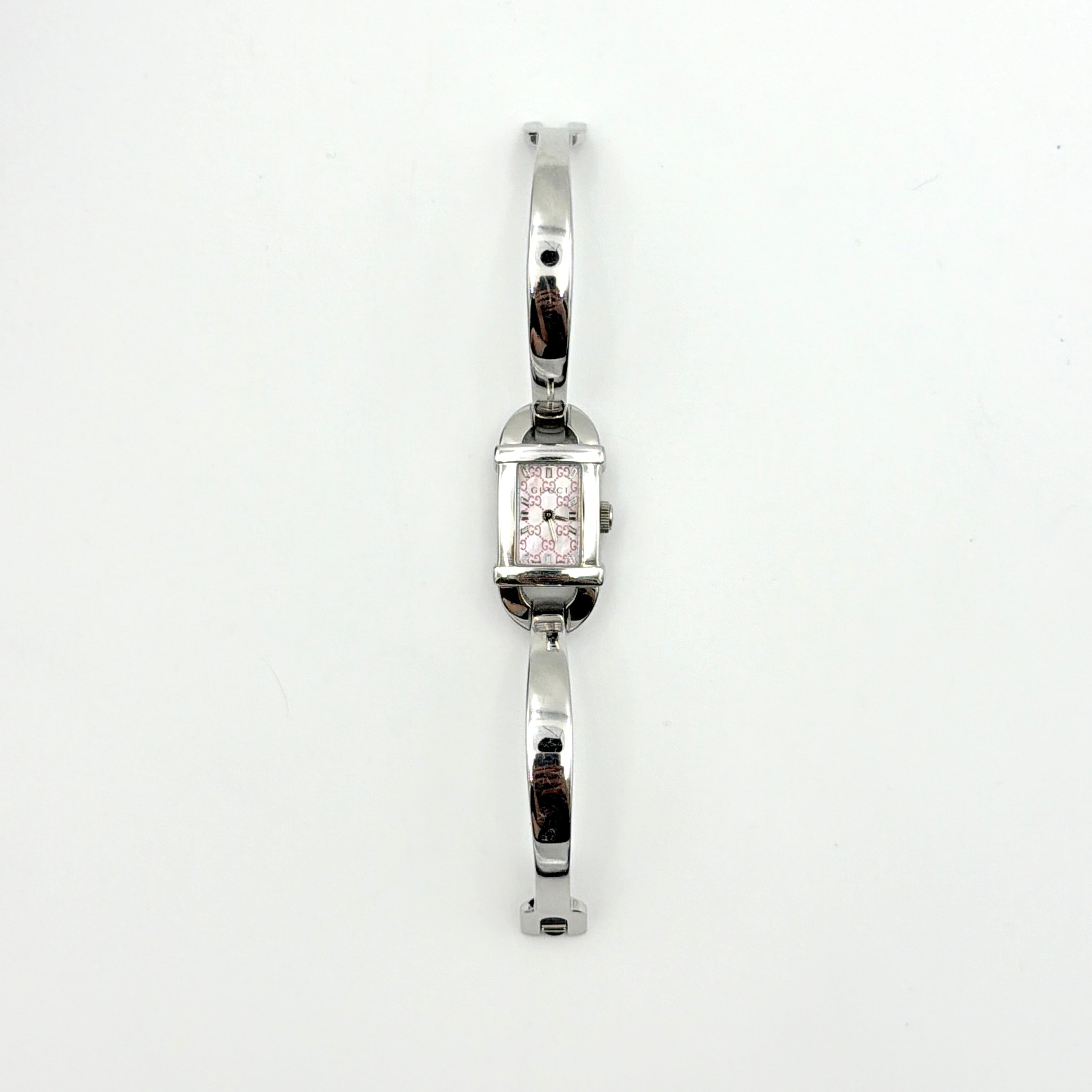 Gucci 6800L GG Bangle Watch in stainless steel with a pink monogram dial, displayed in its original box with branded booklet.