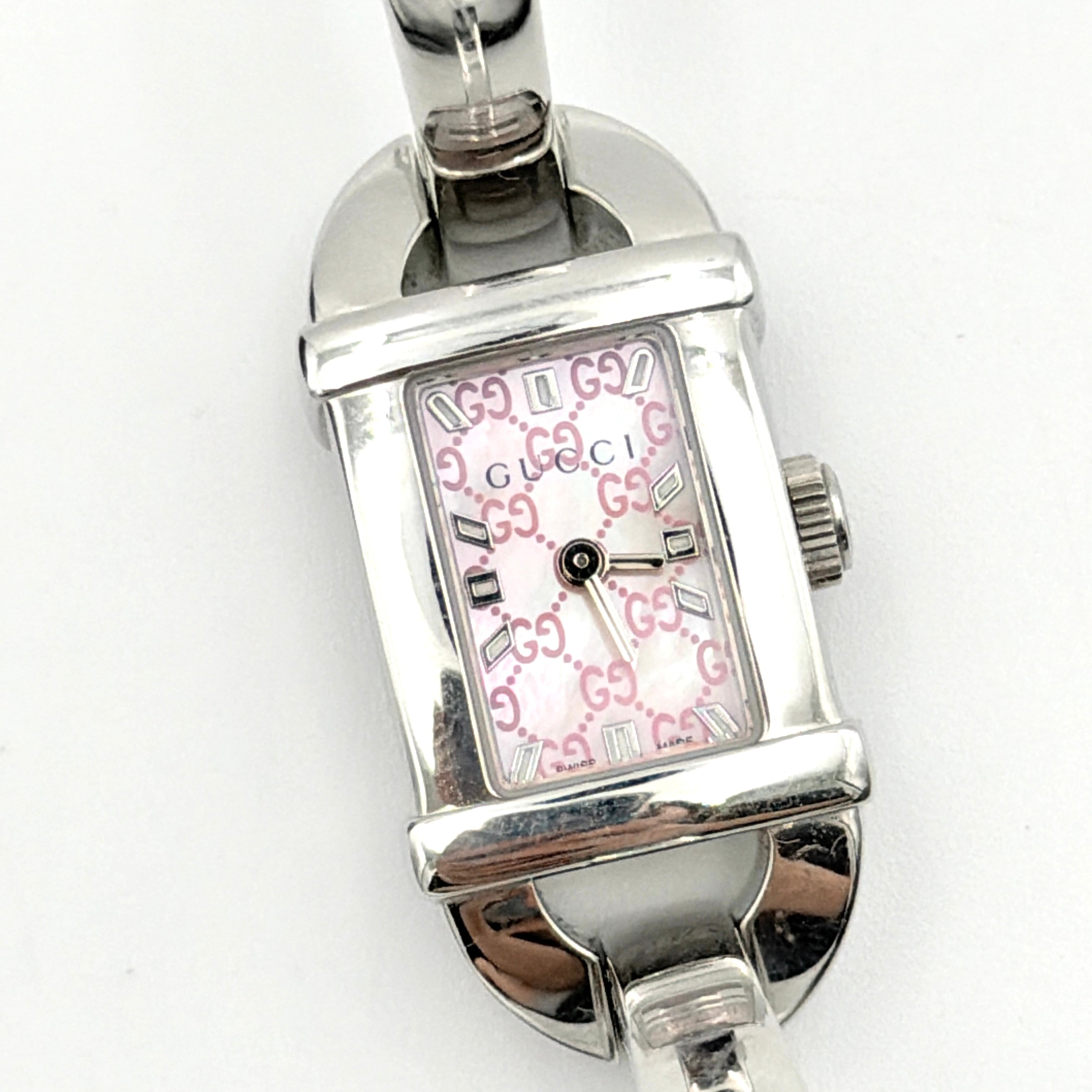 Gucci 6800L GG Bangle Watch in stainless steel with a pink monogram dial, displayed in its original box with branded booklet.