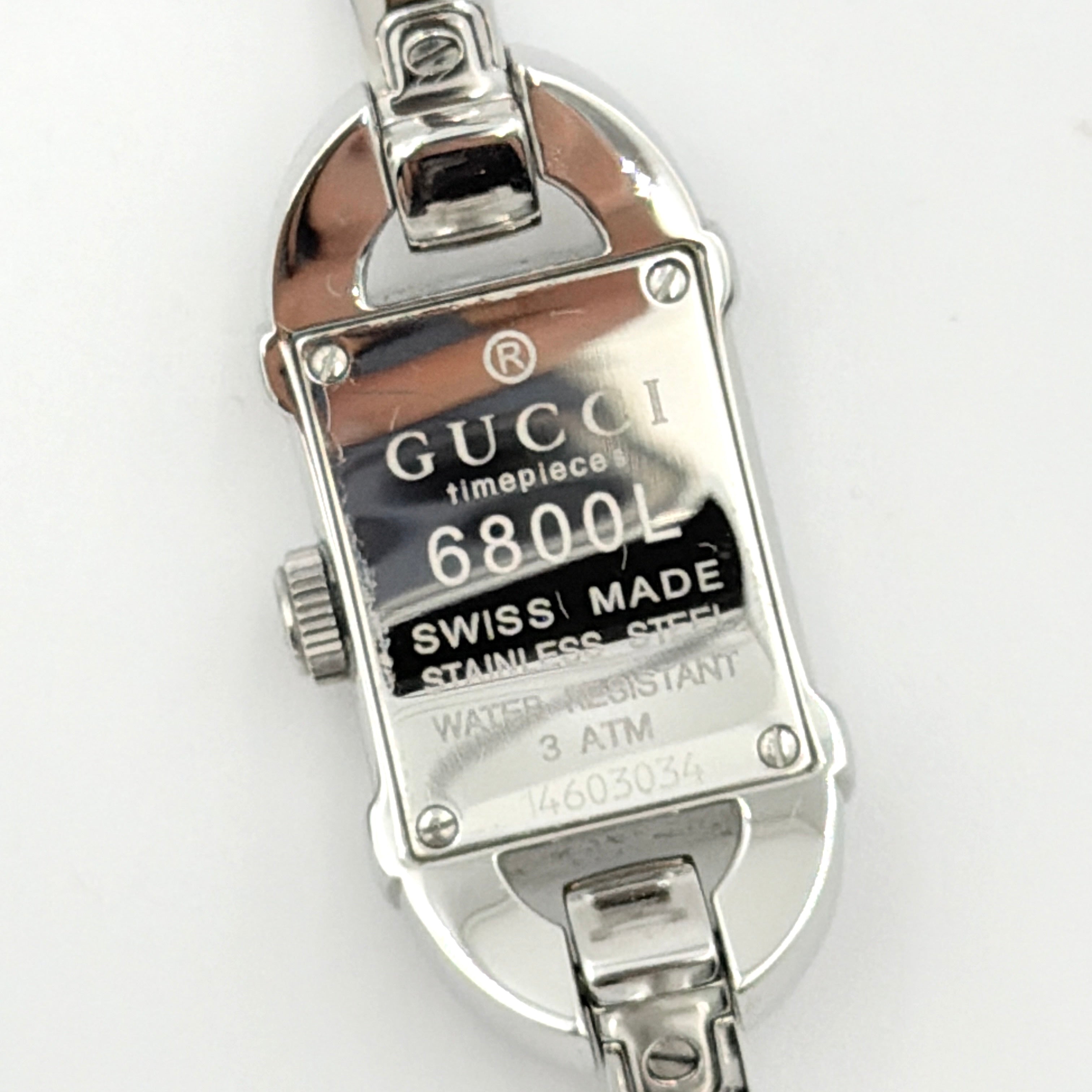 Gucci 6800L GG Bangle Watch in stainless steel with a pink monogram dial, displayed in its original box with branded booklet.