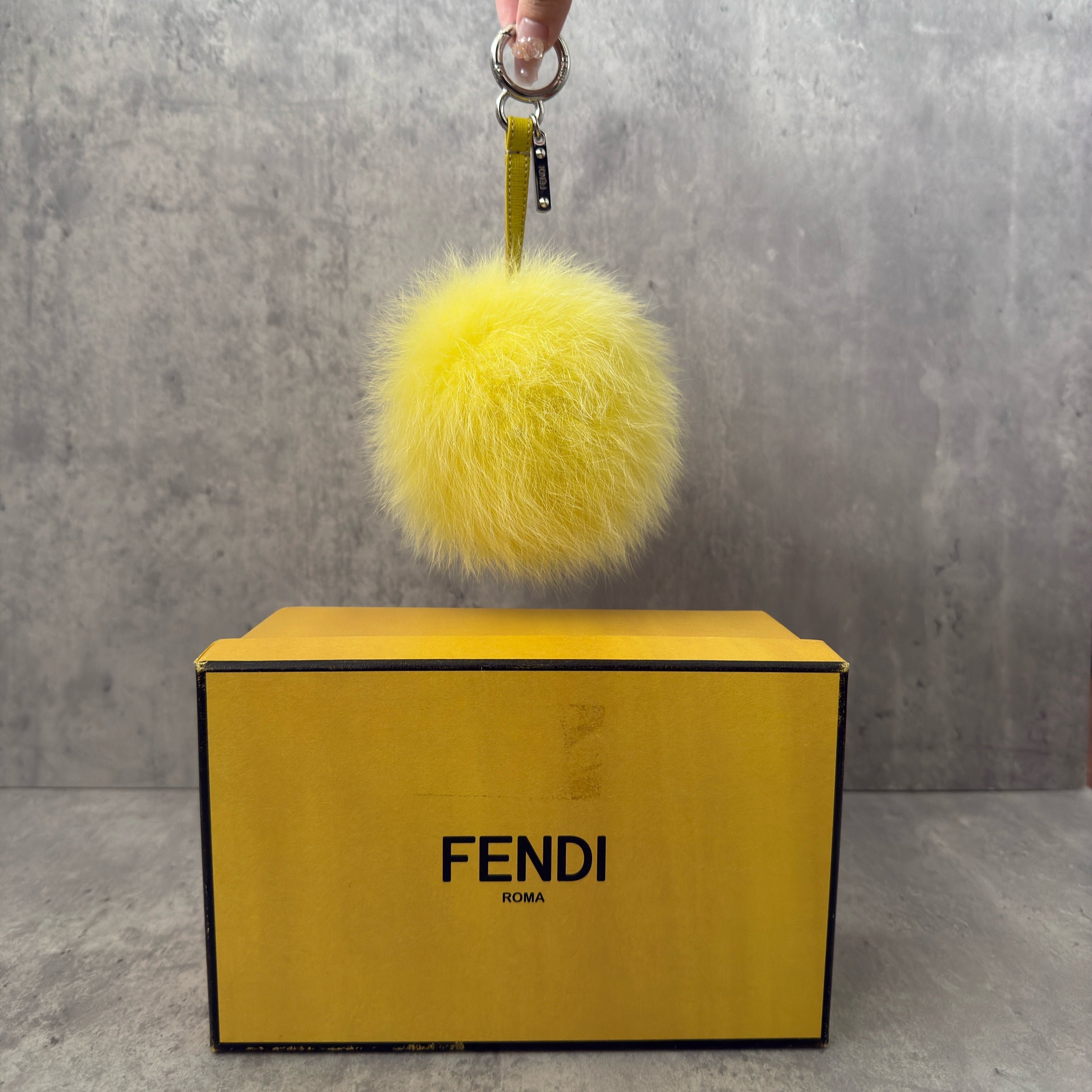 Fendi Yellow Fur Bag Charm with plush fox fur, silver-tone keyring, and leather strap.
