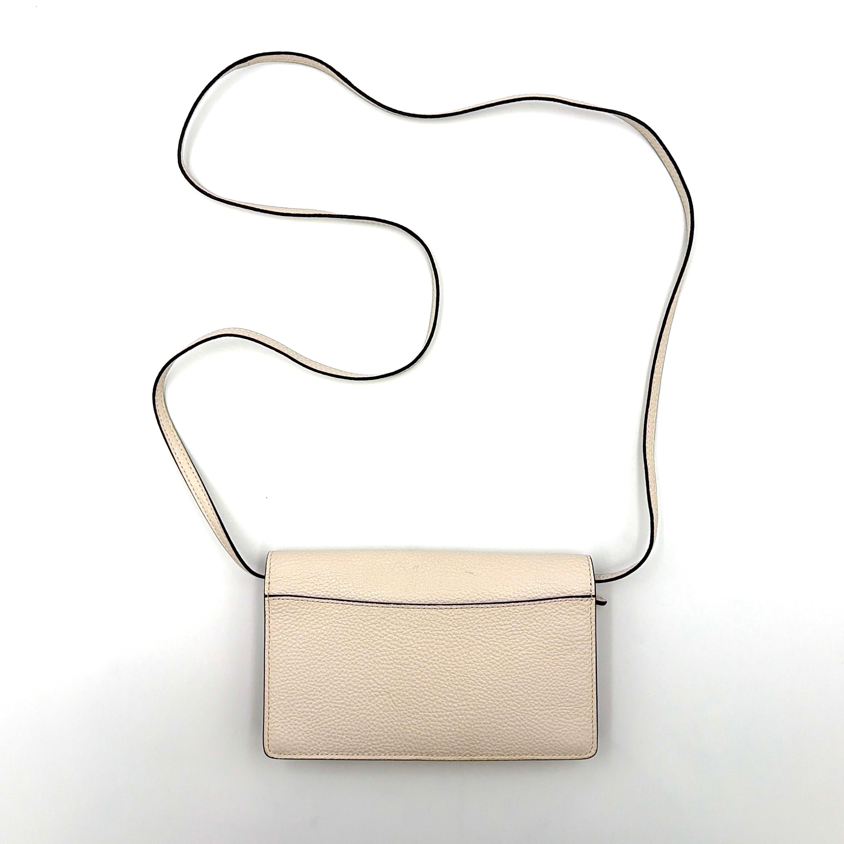 Coach x Disney Dumbo cream foldover crossbody bag with Dumbo illustration and slender strap, displayed against white background.
