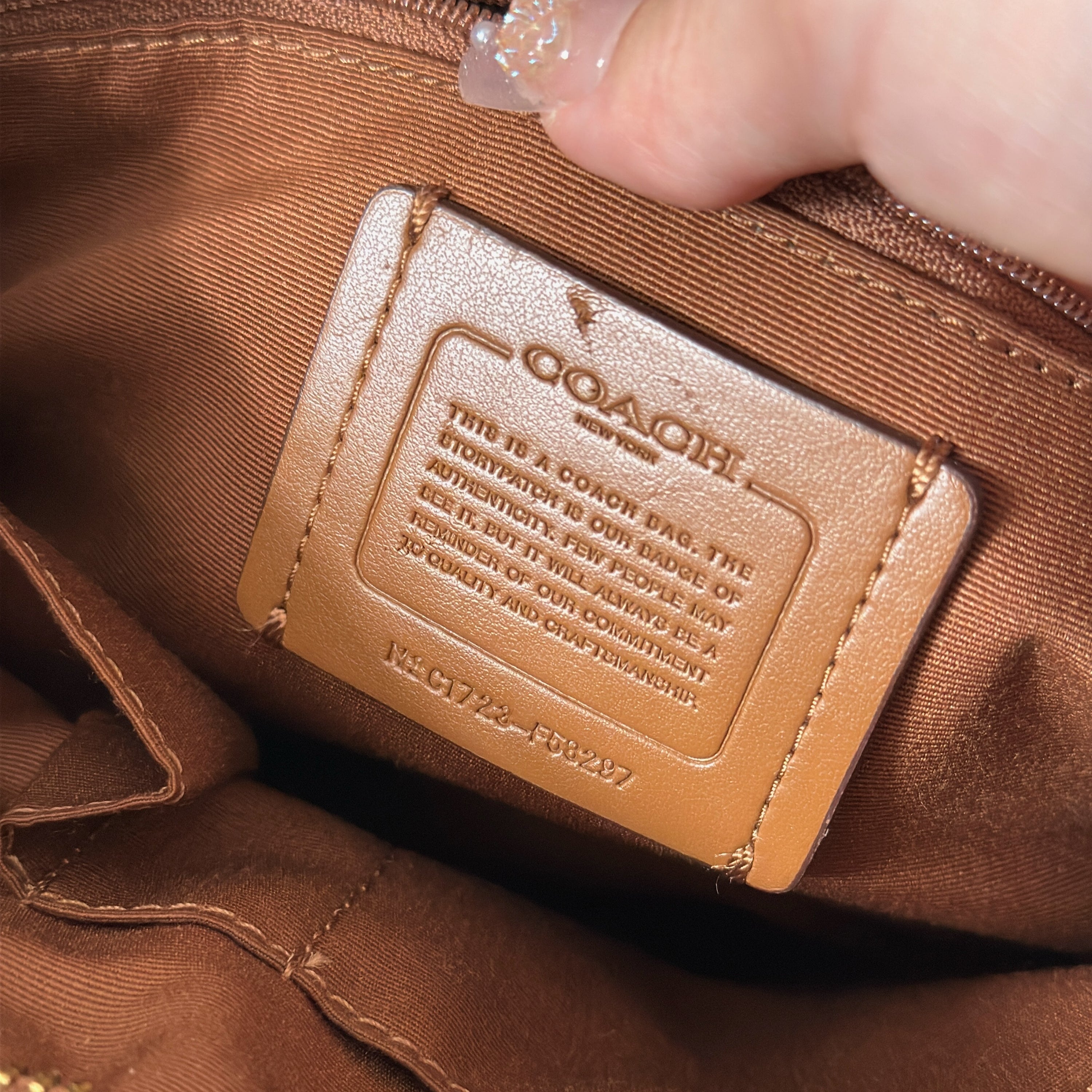 Coach Signature File Crossbody Bag in beige and brown monogram canvas, featuring leather trim, gold-tone hardware, and an adjustable crossbody strap.