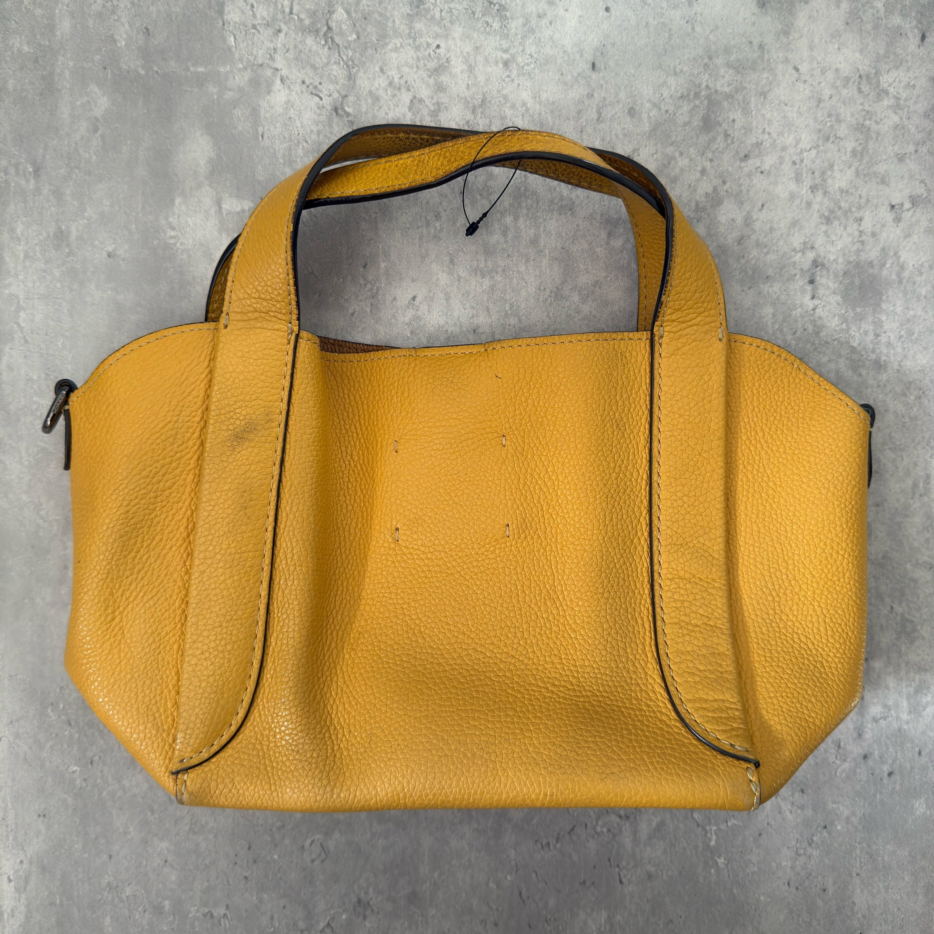 Coach Mini Yellow Leather Bag with pebbled leather texture, dual top handles, and a spacious open interior.