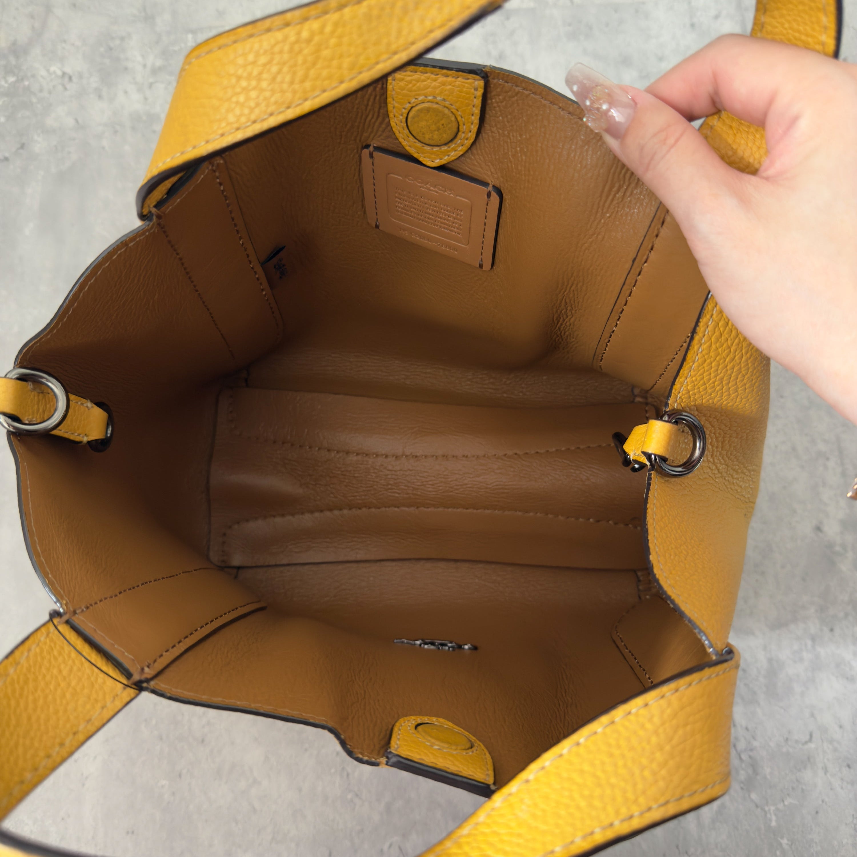 Coach Mini Yellow Leather Bag with pebbled leather texture, dual top handles, and a spacious open interior.