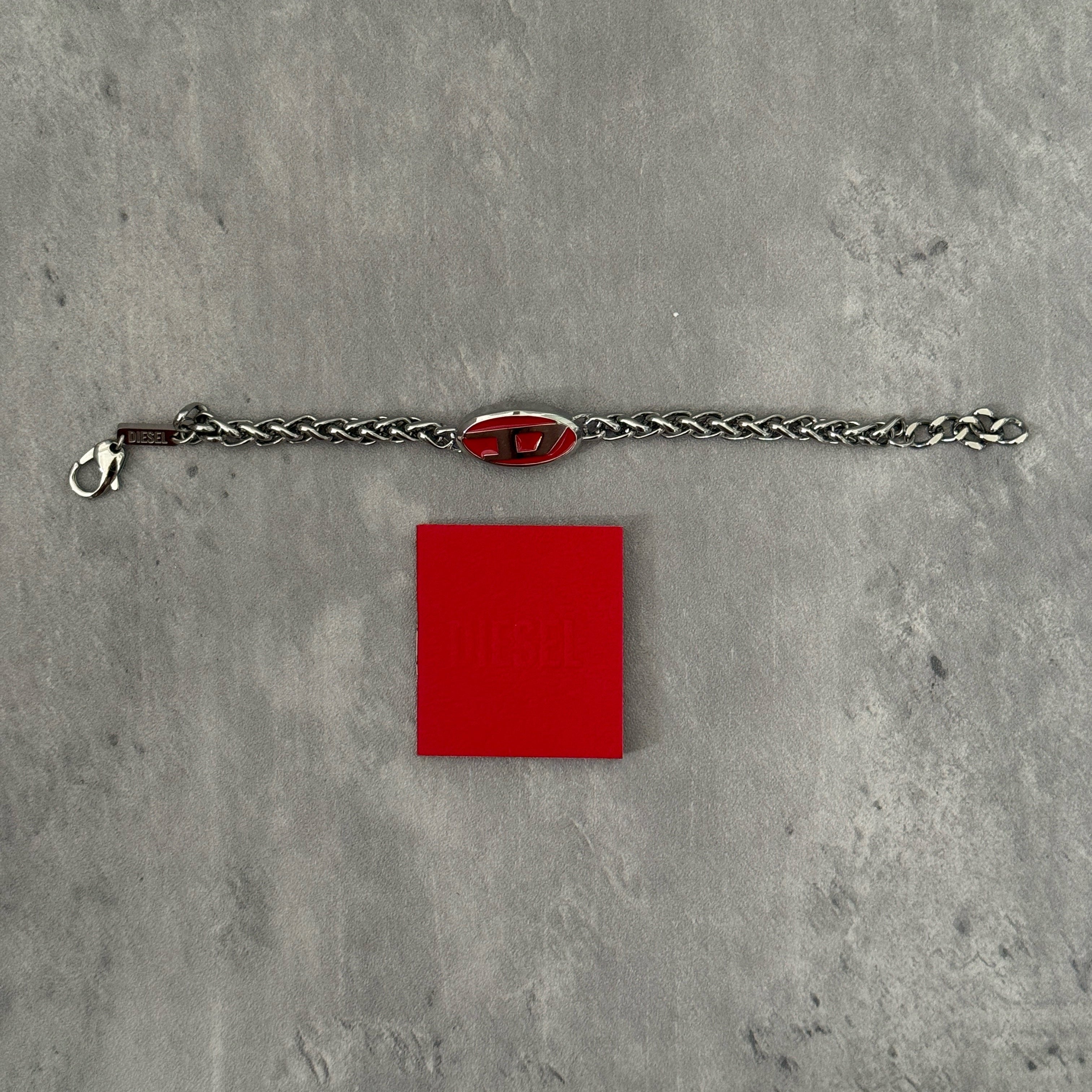 Diesel red lacquer and stainless steel chain bracelet with bold logo centerpiece and lobster clasp closure.