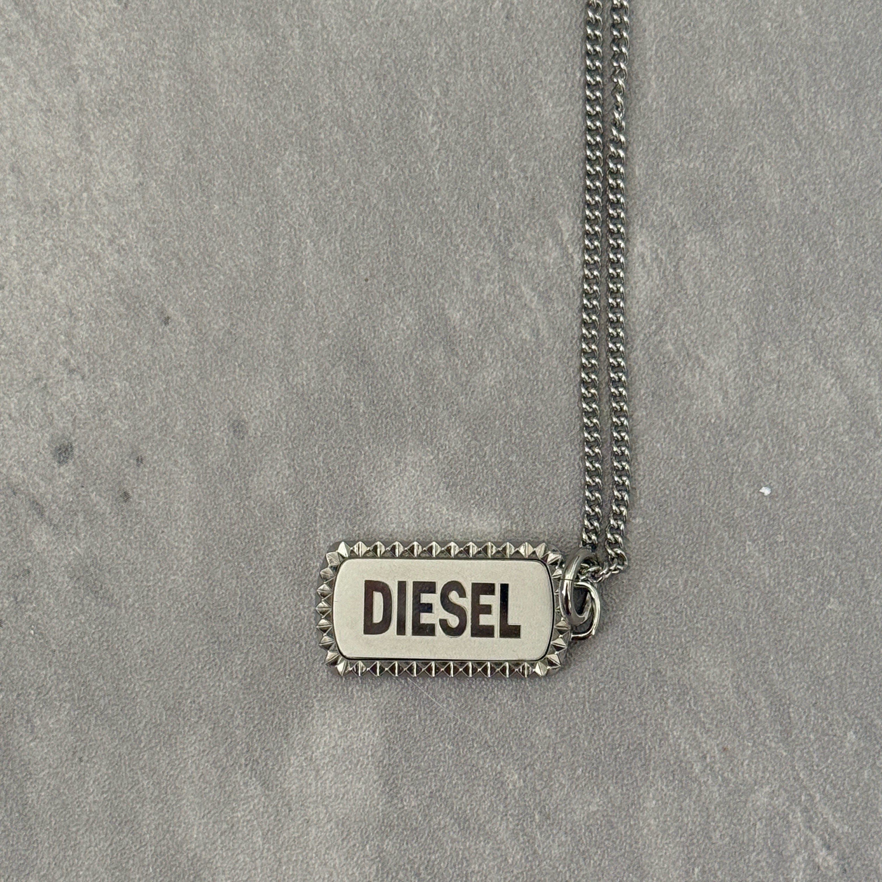 Diesel Signature Stainless Steel Dog Tag Necklace with a studded border and logo engraving on a silver-tone chain.