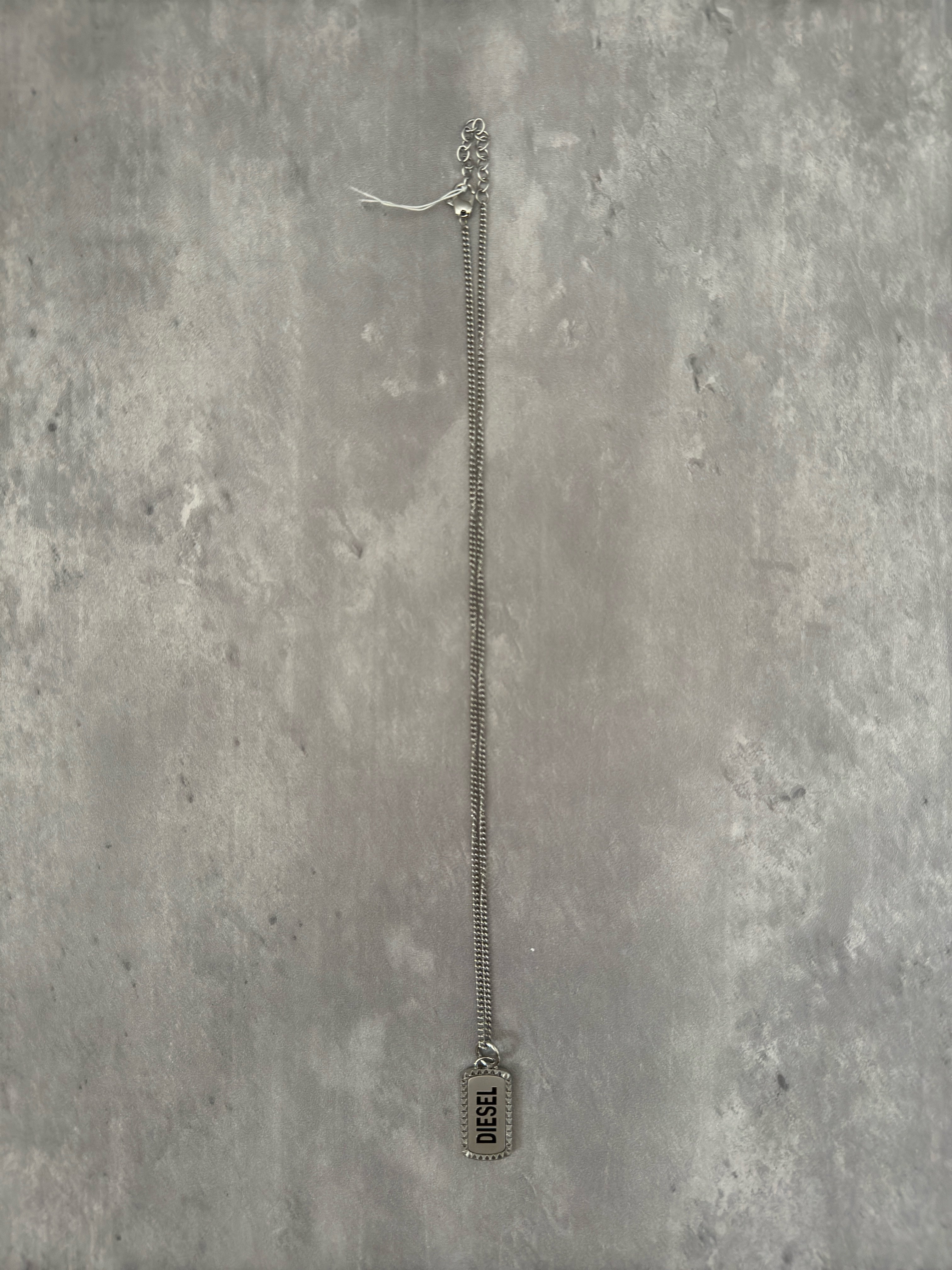 Diesel Signature Stainless Steel Dog Tag Necklace with a studded border and logo engraving on a silver-tone chain.