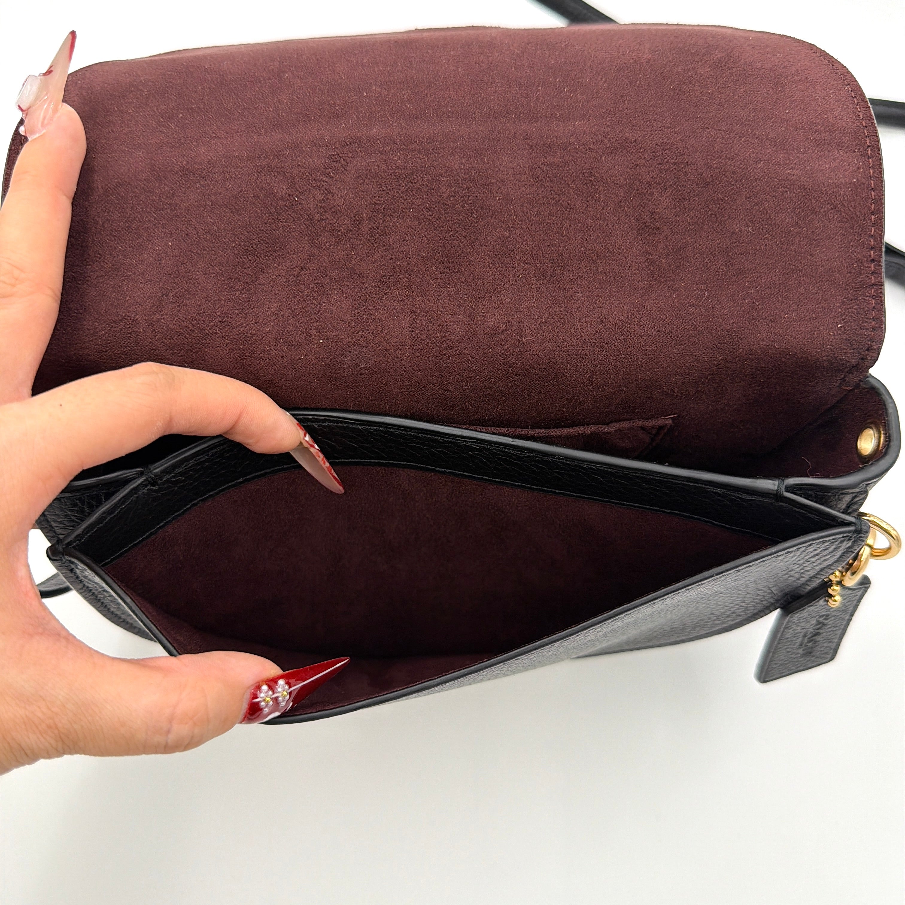 Coach Ellen Crossbody Bag in black pebbled leather with a half-moon silhouette, gold-tone hardware, and adjustable strap.