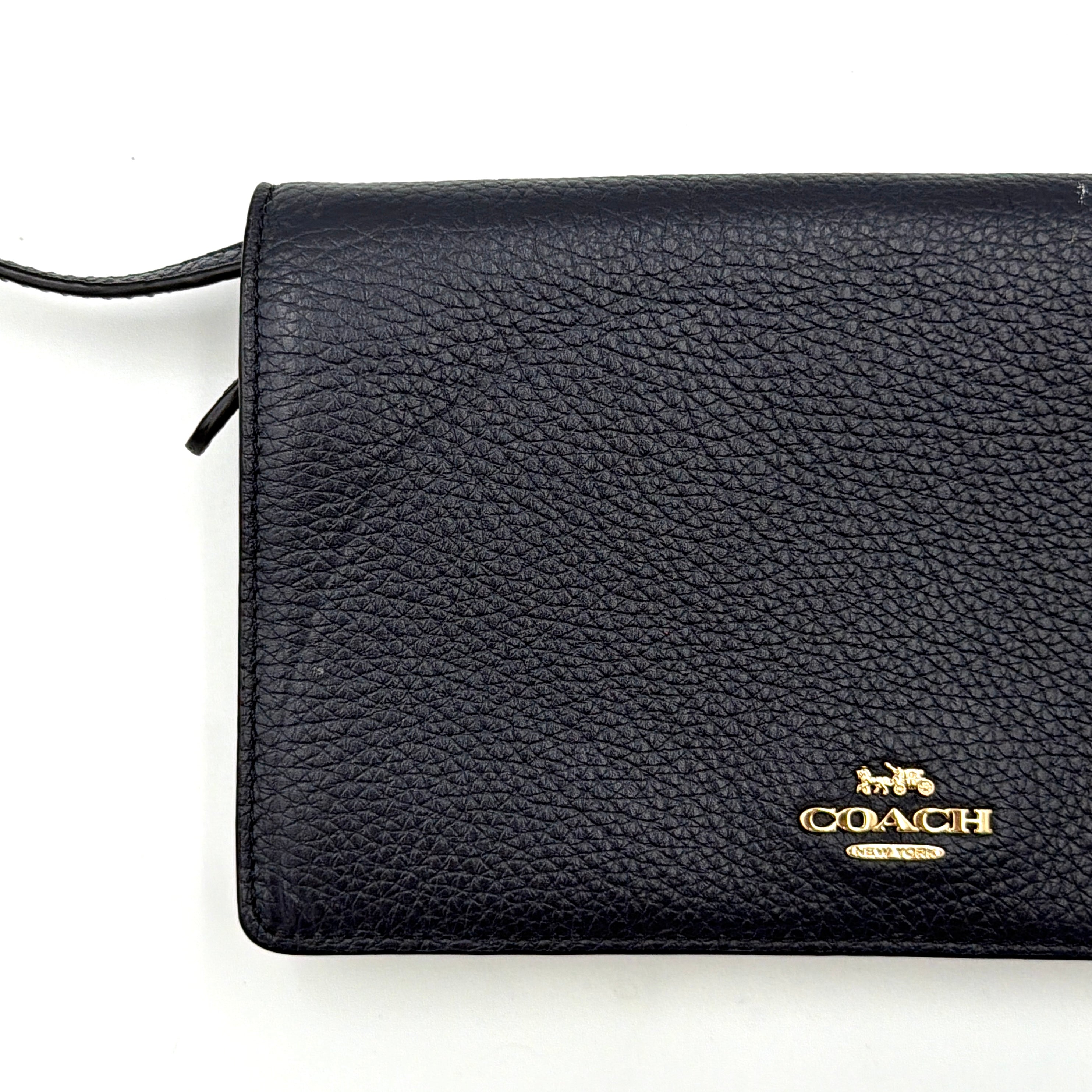 Coach Anna Foldover Clutch Crossbody Bag in navy pebbled leather with slim strap and gold logo detailing.