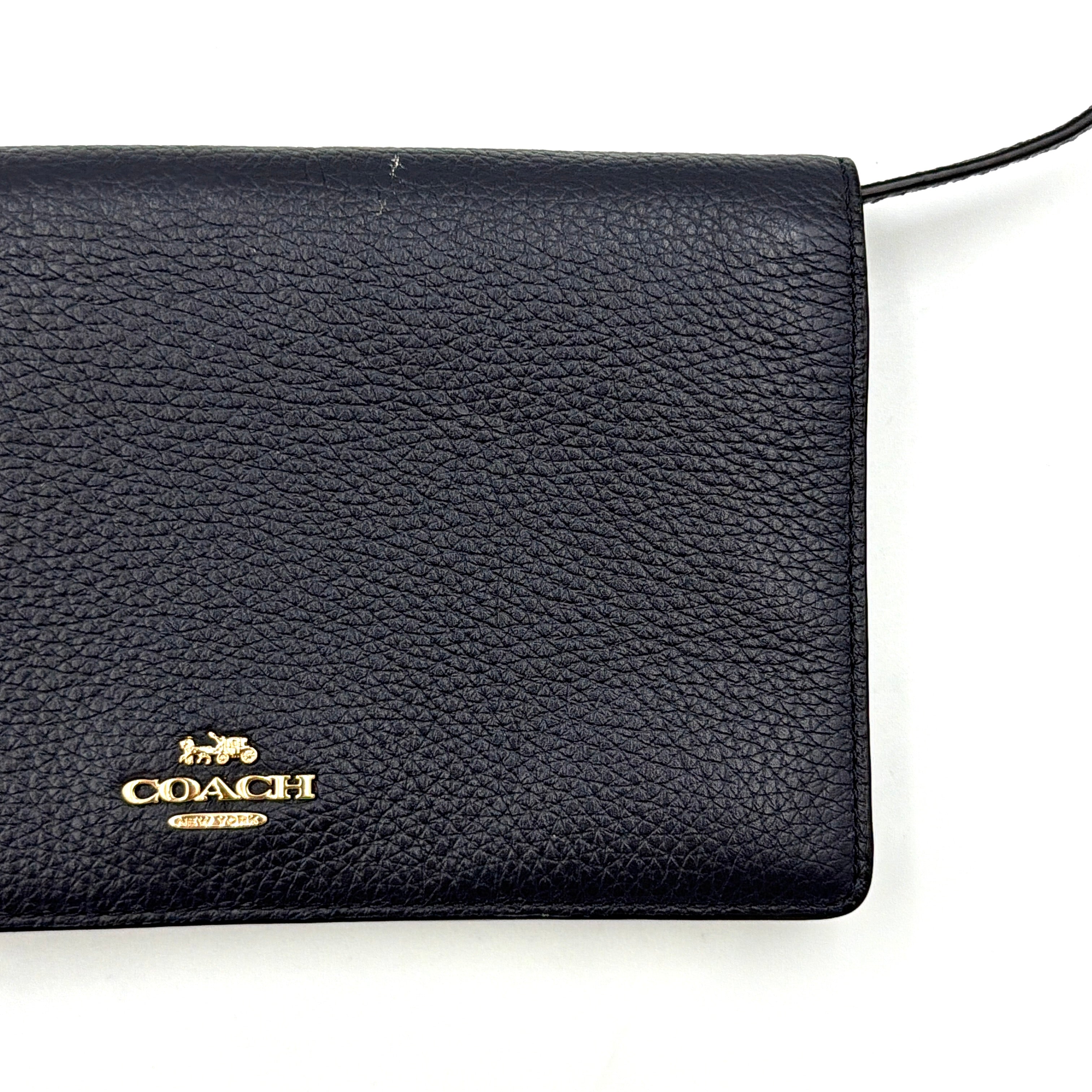 Coach Anna Foldover Clutch Crossbody Bag in navy pebbled leather with slim strap and gold logo detailing.