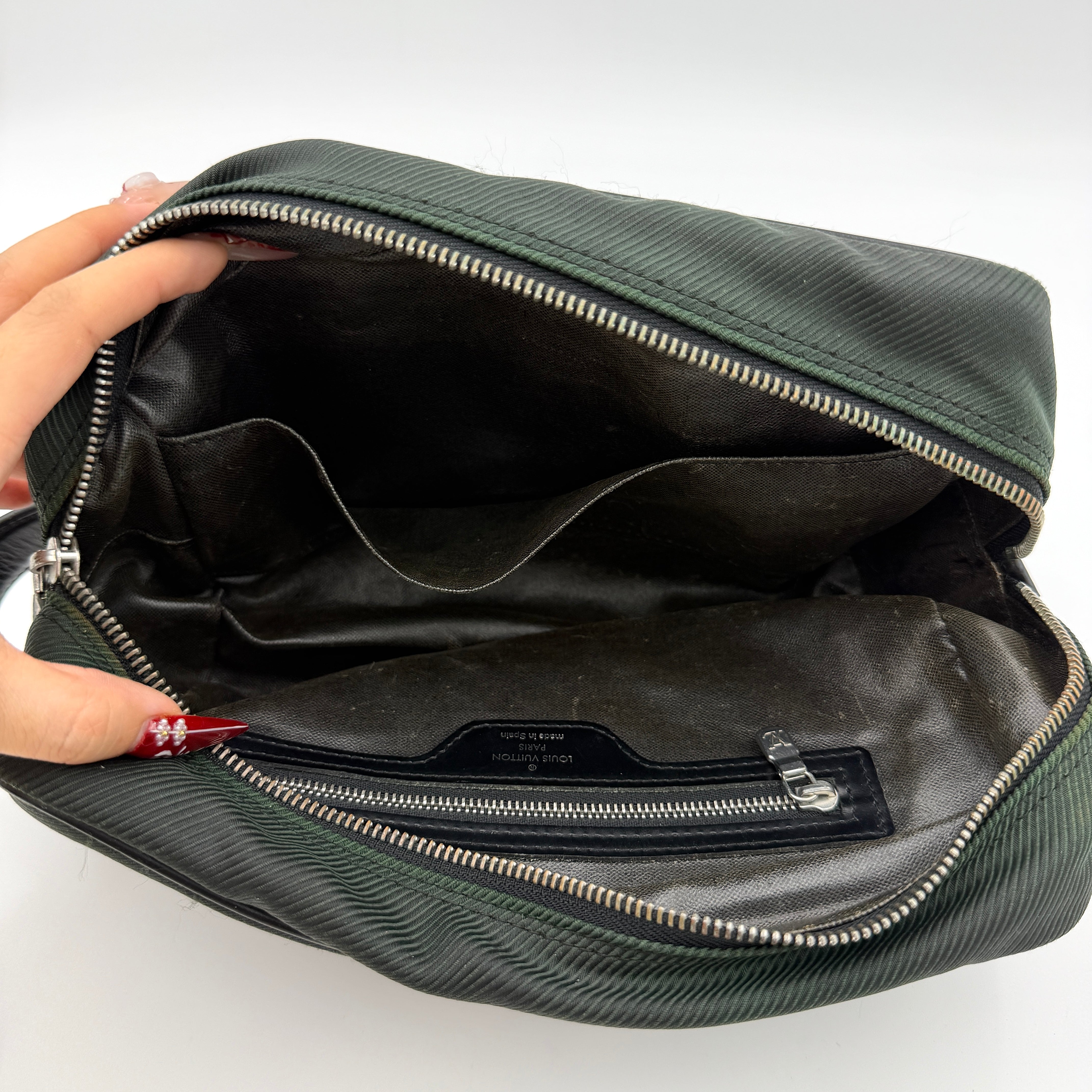 Louis Vuitton Taiga Parana Clutch Bag in deep green Taiga leather with black leather handle and silver-tone zipper, shown from the front.