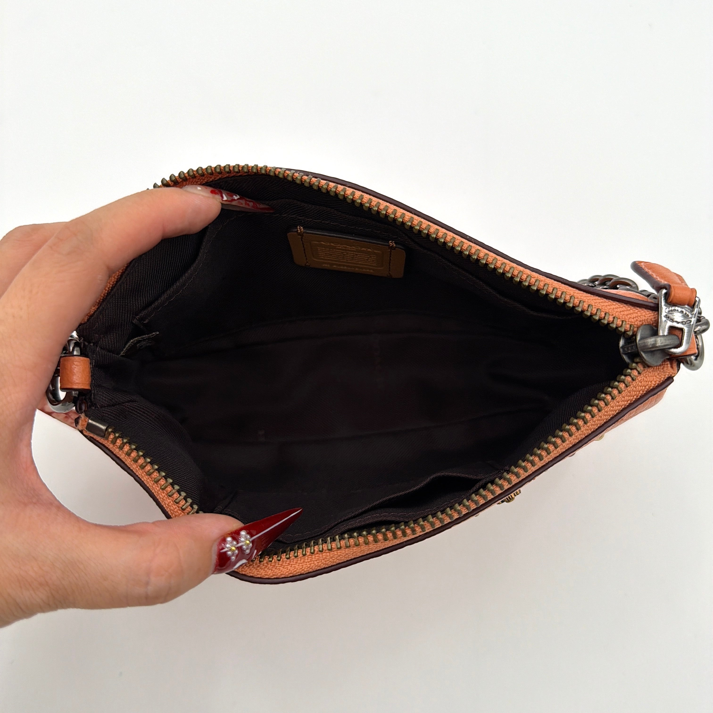 Coach Nolita 19 Prairie Rivets Shoulder Bag in bold orange pebbled leather with mixed metal rivet embellishments and chunky chain strap.
