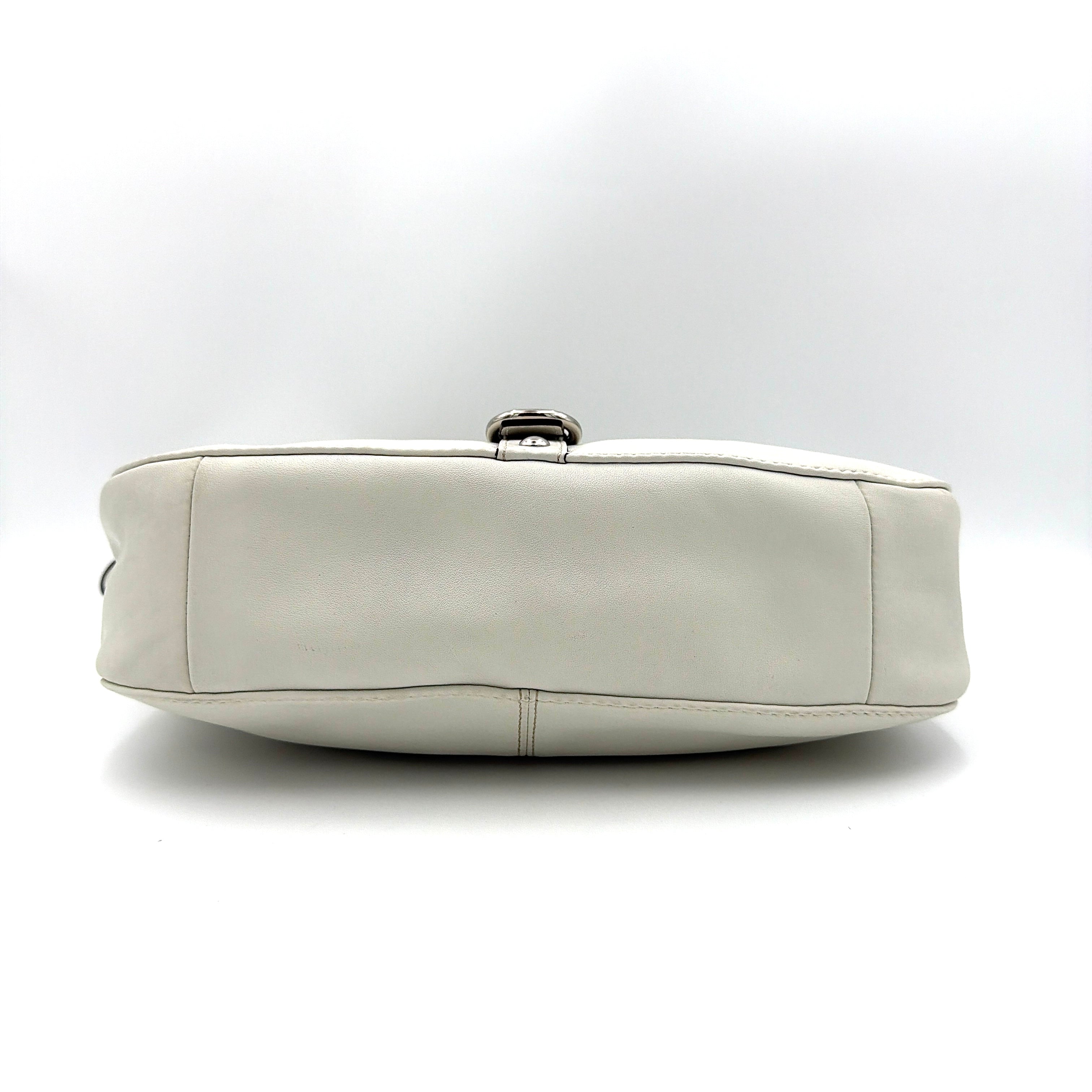 Coach 2Way Buckle Shoulder Bag in smooth ivory leather with silver-tone hardware and an adjustable strap, styled against a white background.