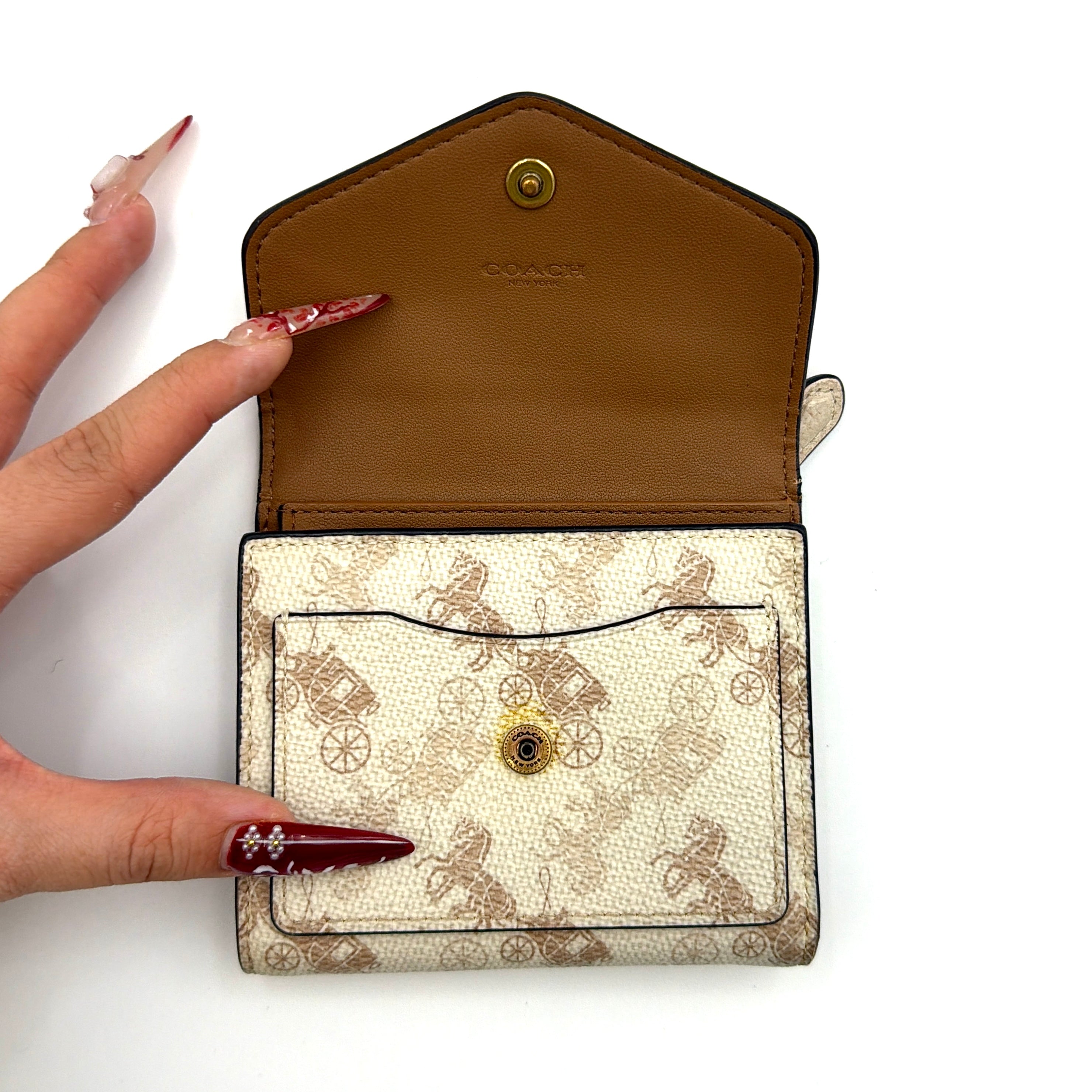 Coach Wyn Horse & Carriage Small Wallet in cream with gold hardware, featuring an envelope flap and iconic horse and carriage motif.