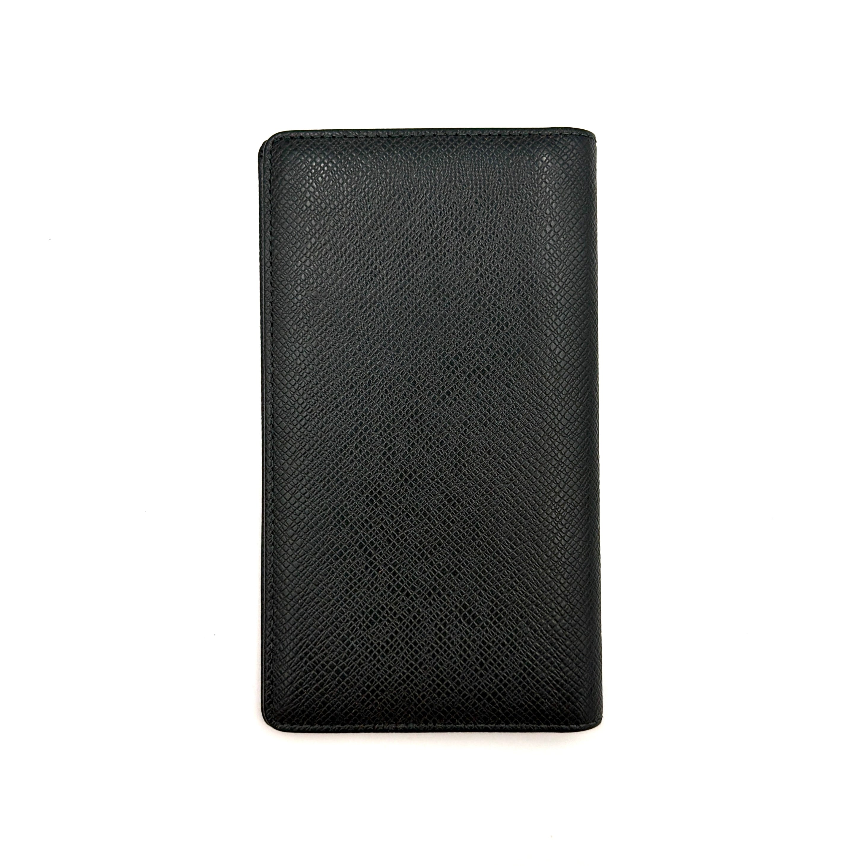 A Louis Vuitton Taiga Brazza Wallet in dark green, showcasing fine cross-grain leather texture and the understated LV monogram debossed on the front.