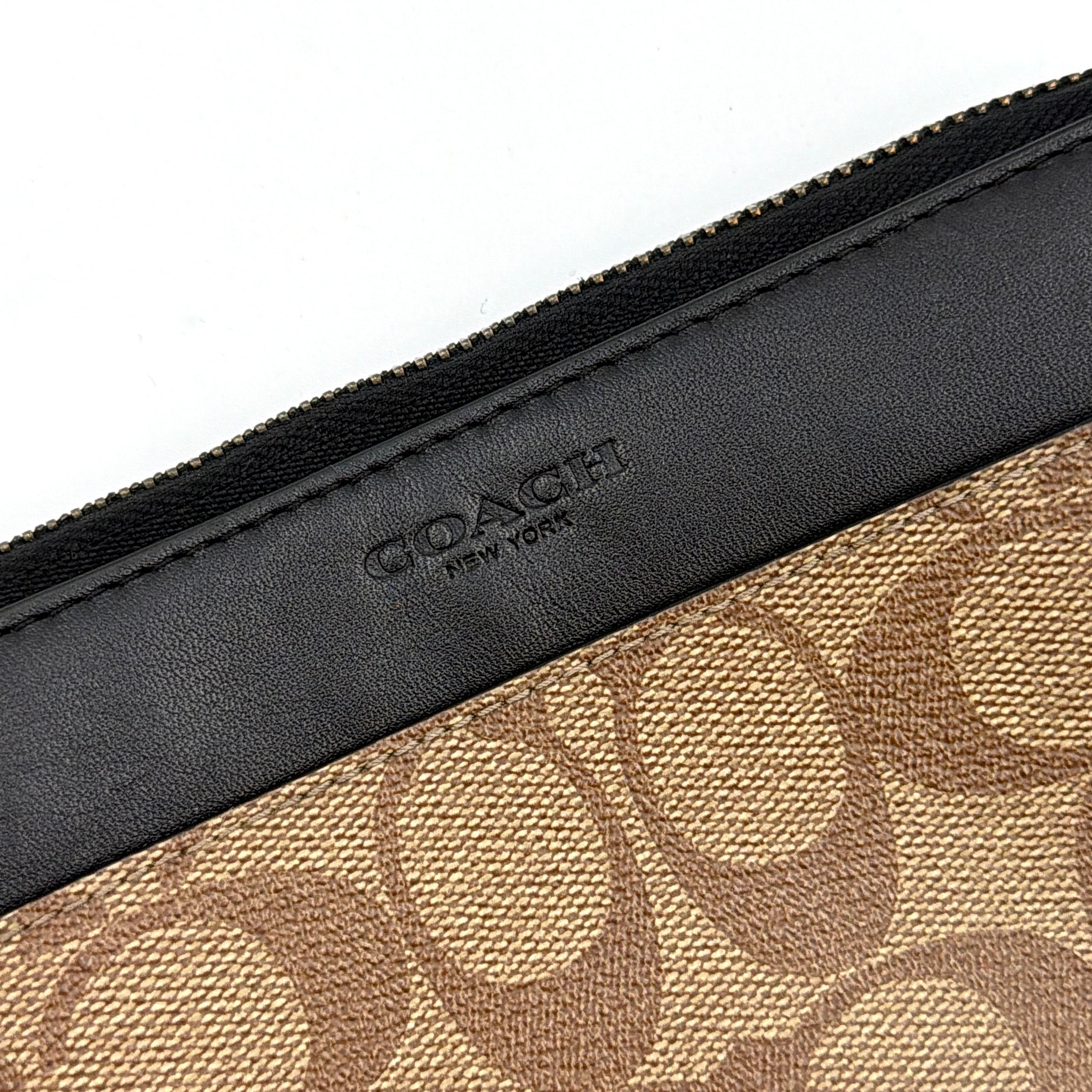 Coach Signature Accordion Long Wallet in beige and black canvas with black leather trim, featuring zip-around closure.