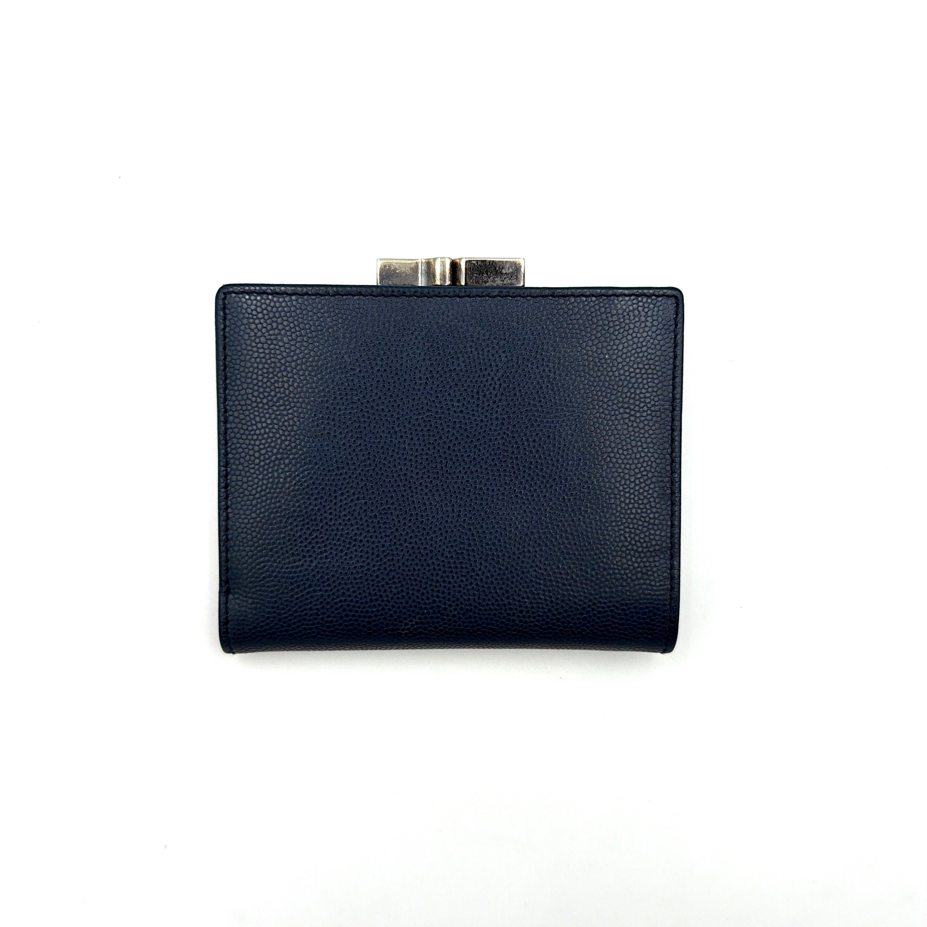 Dior compact navy blue leather wallet with silver-tone logo plaque and kiss-lock clasp, showcased against a clean background.