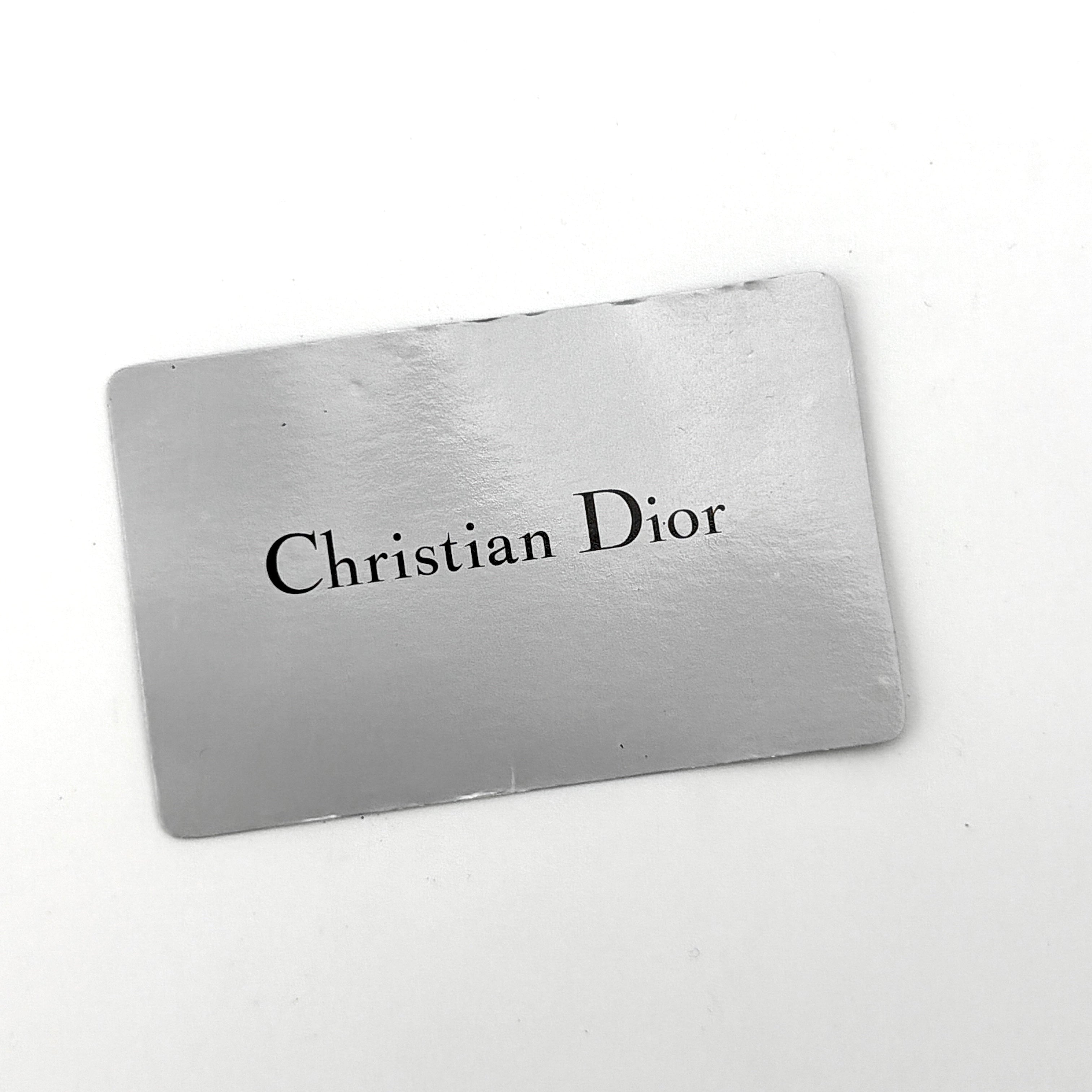 Dior compact navy blue leather wallet with silver-tone logo plaque and kiss-lock clasp, showcased against a clean background.