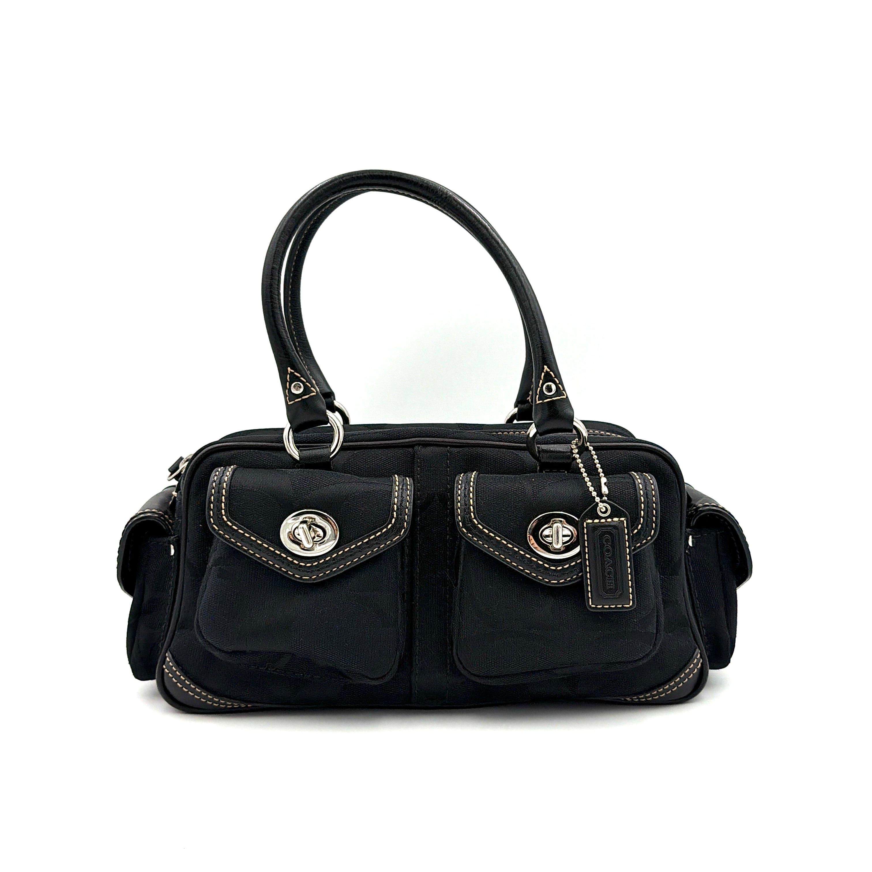 Coach black Signature Gallery satchel with double handles and silver hardware, set against a clean background.