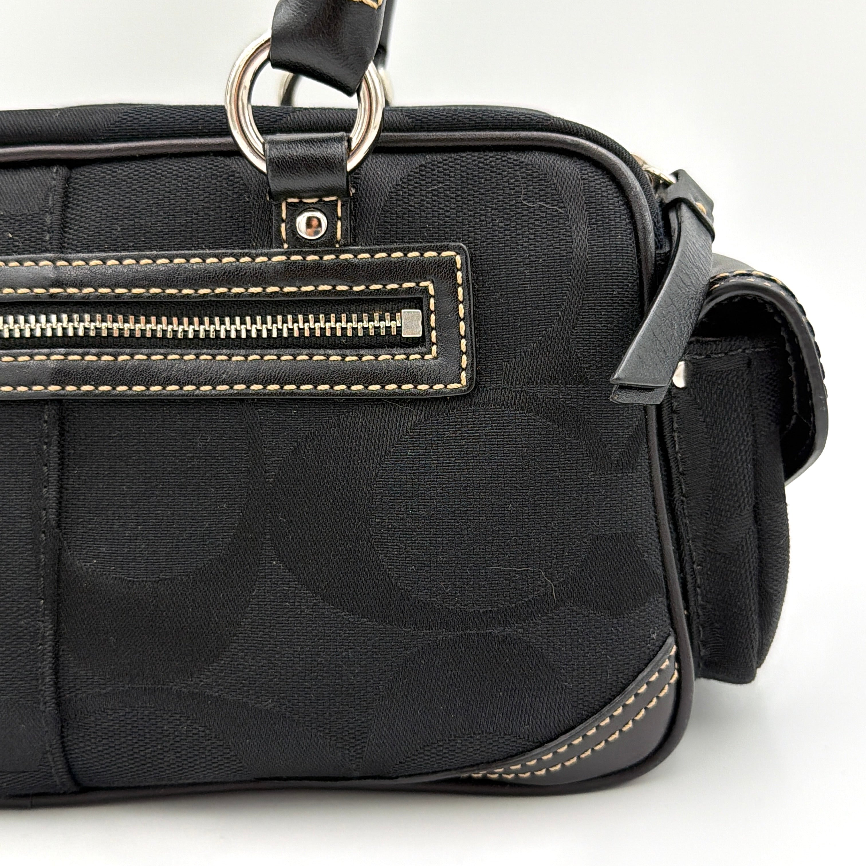 Coach black Signature Gallery satchel with double handles and silver hardware, set against a clean background.