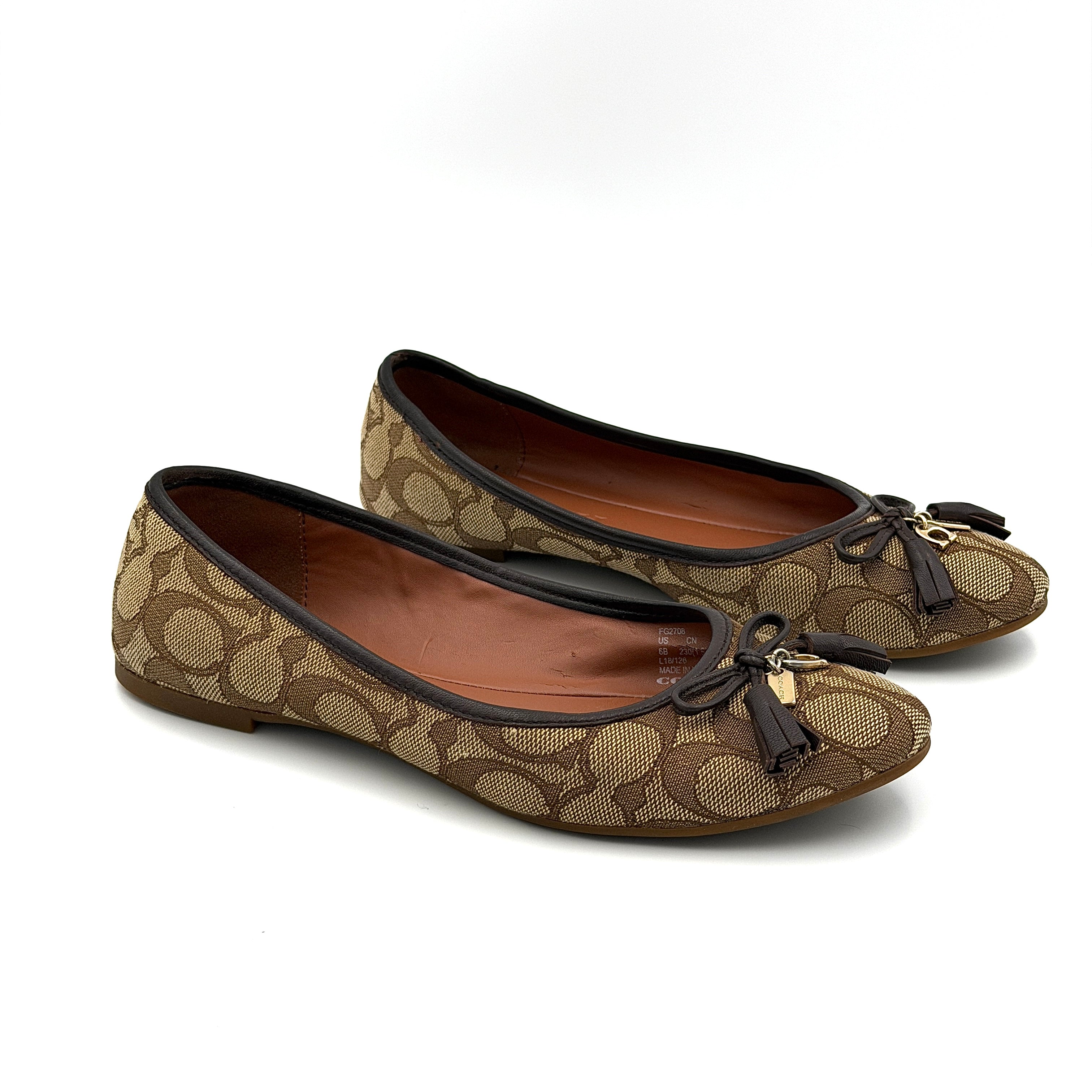 Coach Signature Bennie Jacqueline ballet flats in beige canvas with brown leather trims, shown side by side with tassel and gold charm details.