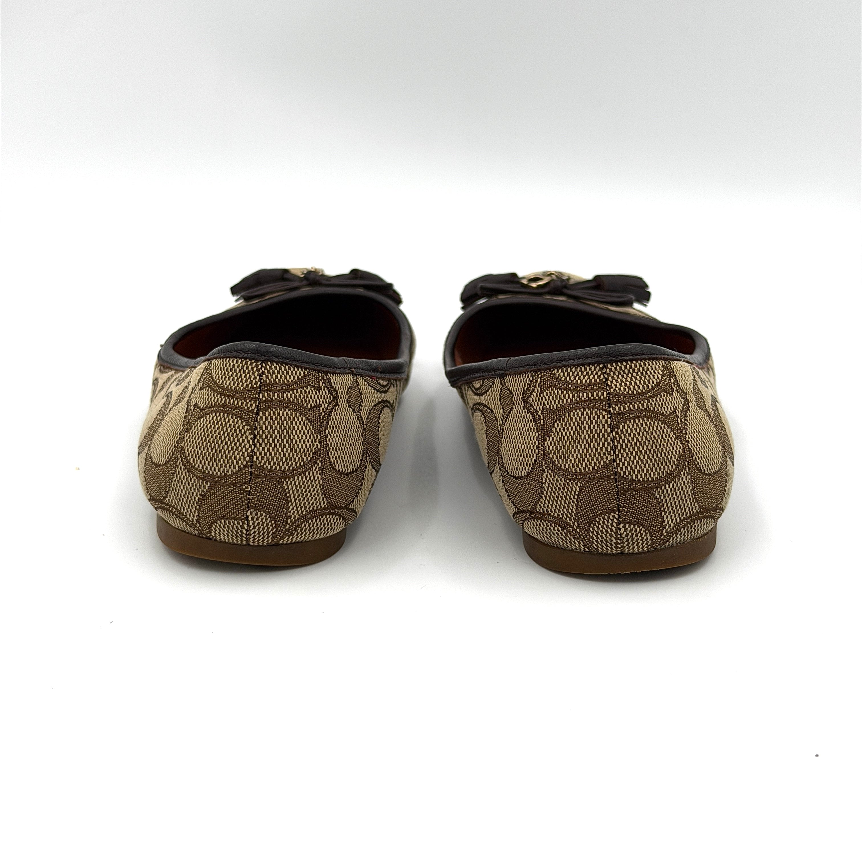 Coach Signature Bennie Jacqueline ballet flats in beige canvas with brown leather trims, shown side by side with tassel and gold charm details.