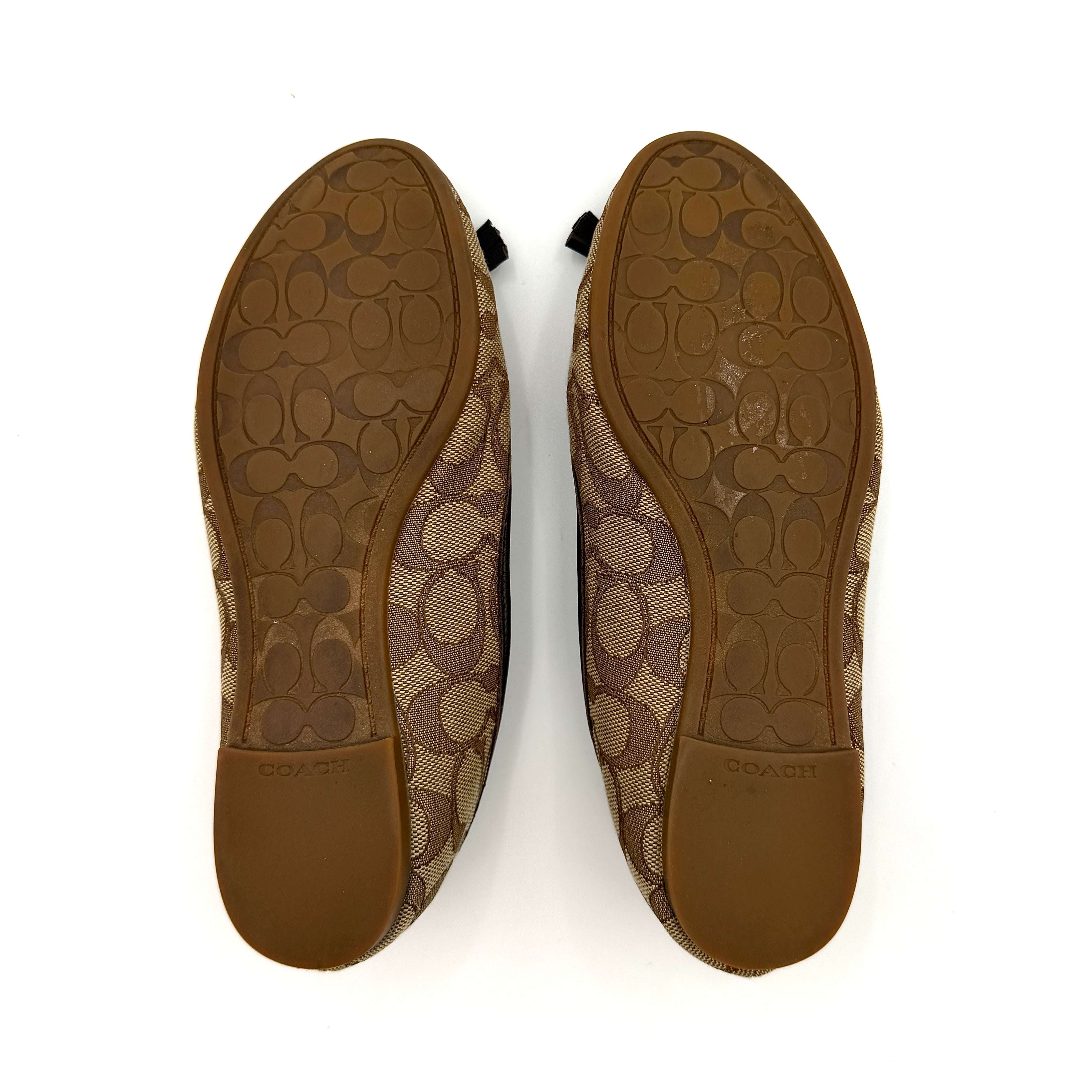 Coach Signature Bennie Jacqueline ballet flats in beige canvas with brown leather trims, shown side by side with tassel and gold charm details.