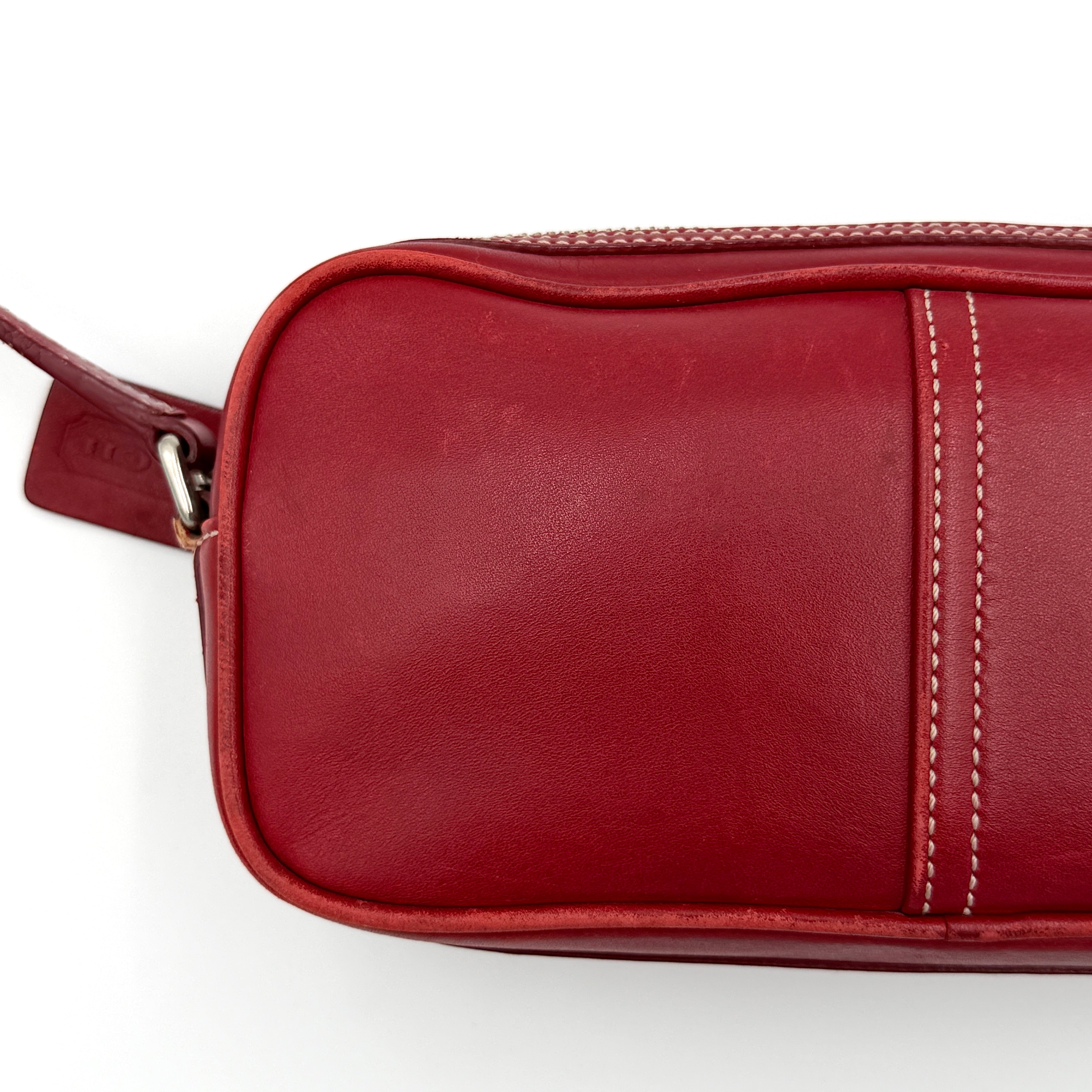 Burgundy Coach Legacy West Crossbody Camera Bag with contrast stitching, exterior zip pocket, and slender adjustable strap.