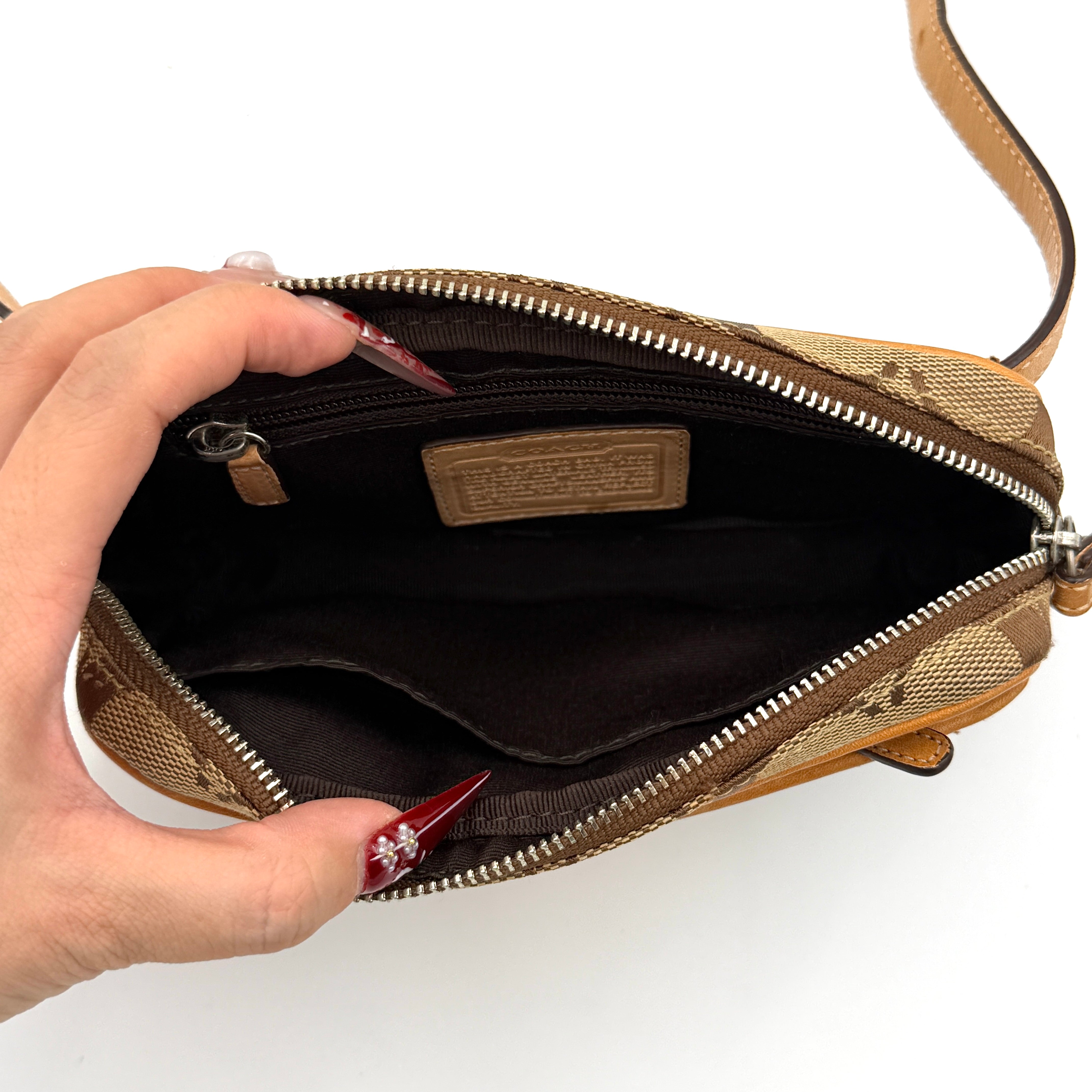 Coach Signature Canvas crossbody bag in beige and tan with iconic 'C' motif, natural leather trim and adjustable strap.