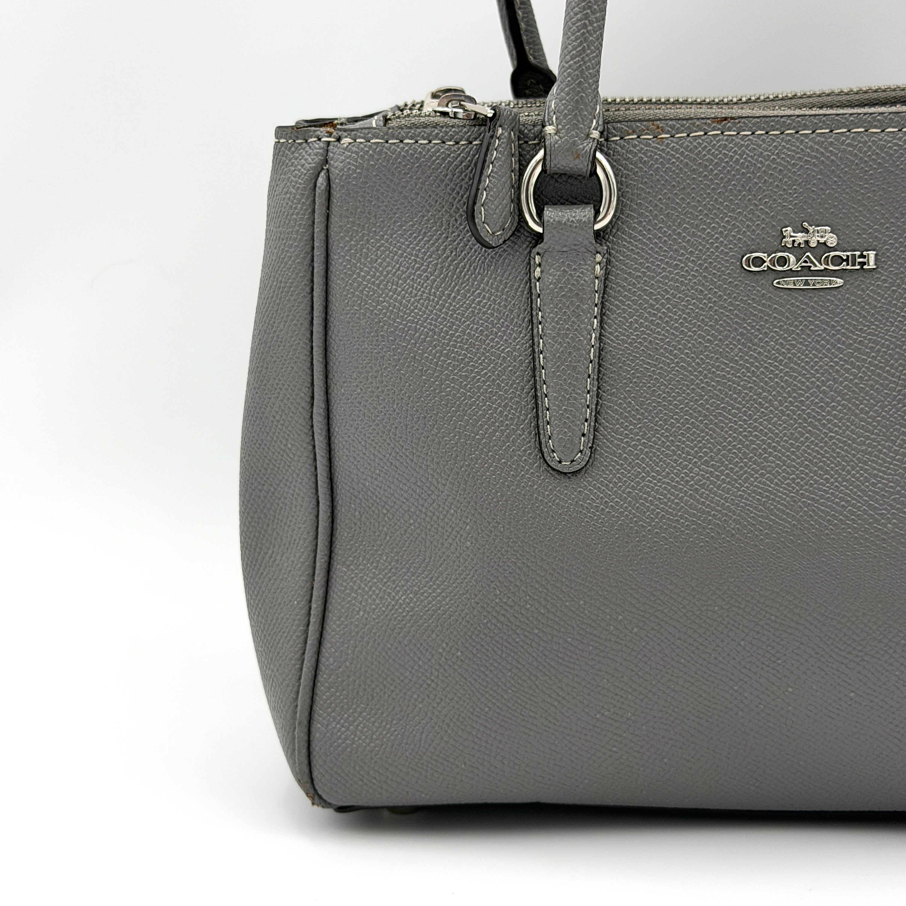 Coach 2Way Mini Surrey Carryall Handbag in grey textured leather with top handles and detachable strap, styled against a clean background.