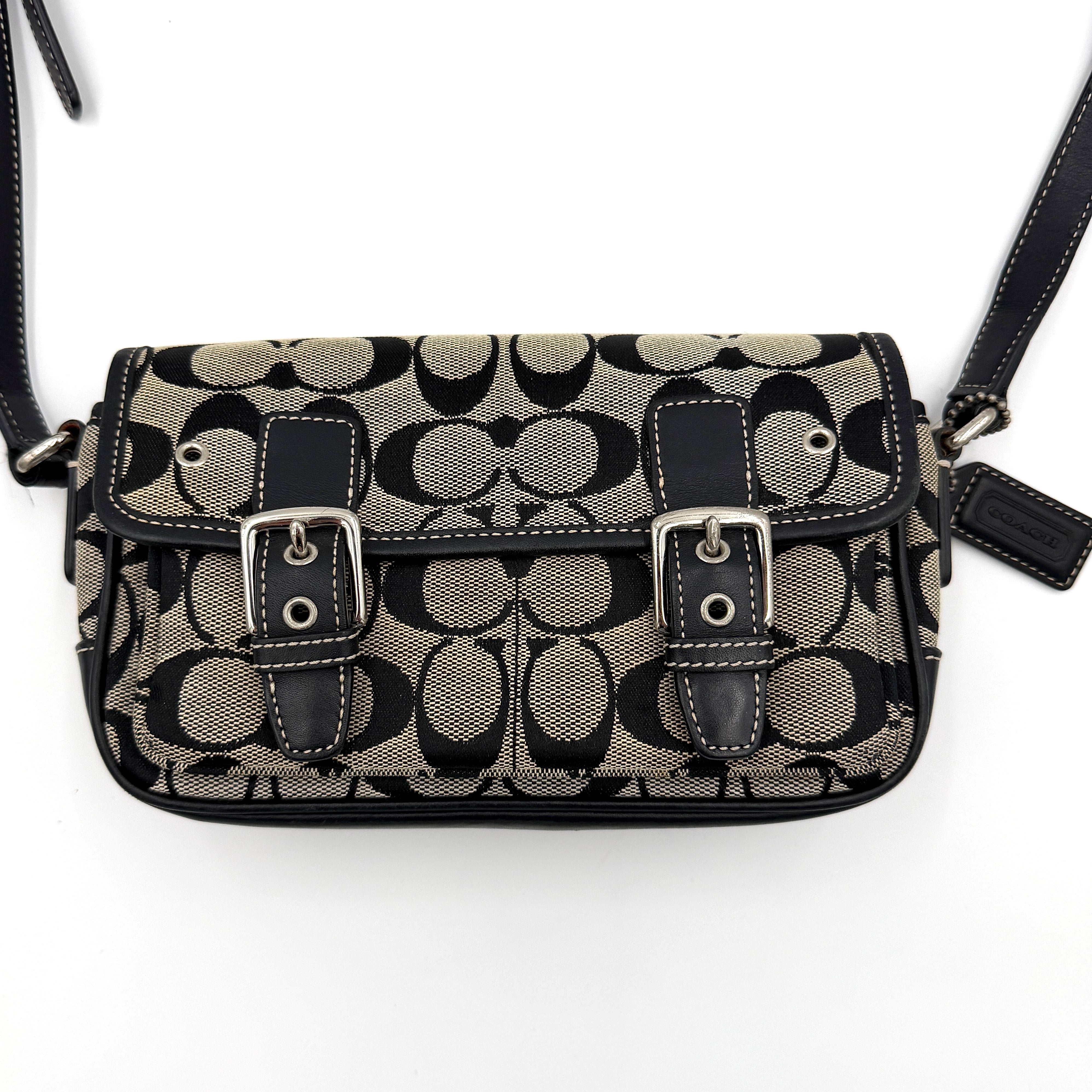 Coach Signature Double Buckle Crossbody bag in grey and black jacquard canvas, accented with black leather trim and dual silver-tone buckle detailing.