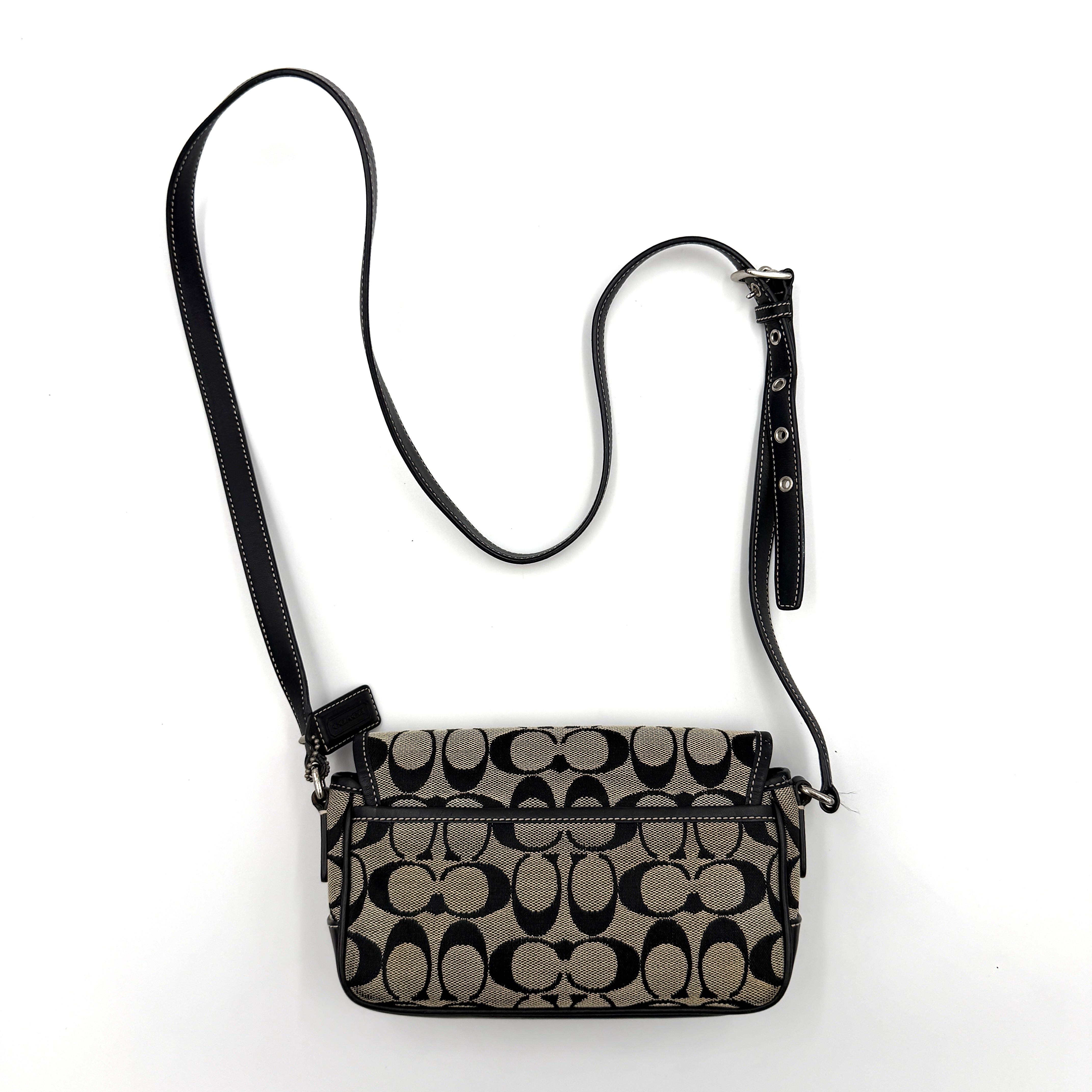 Coach Signature Double Buckle Crossbody bag in grey and black jacquard canvas, accented with black leather trim and dual silver-tone buckle detailing.