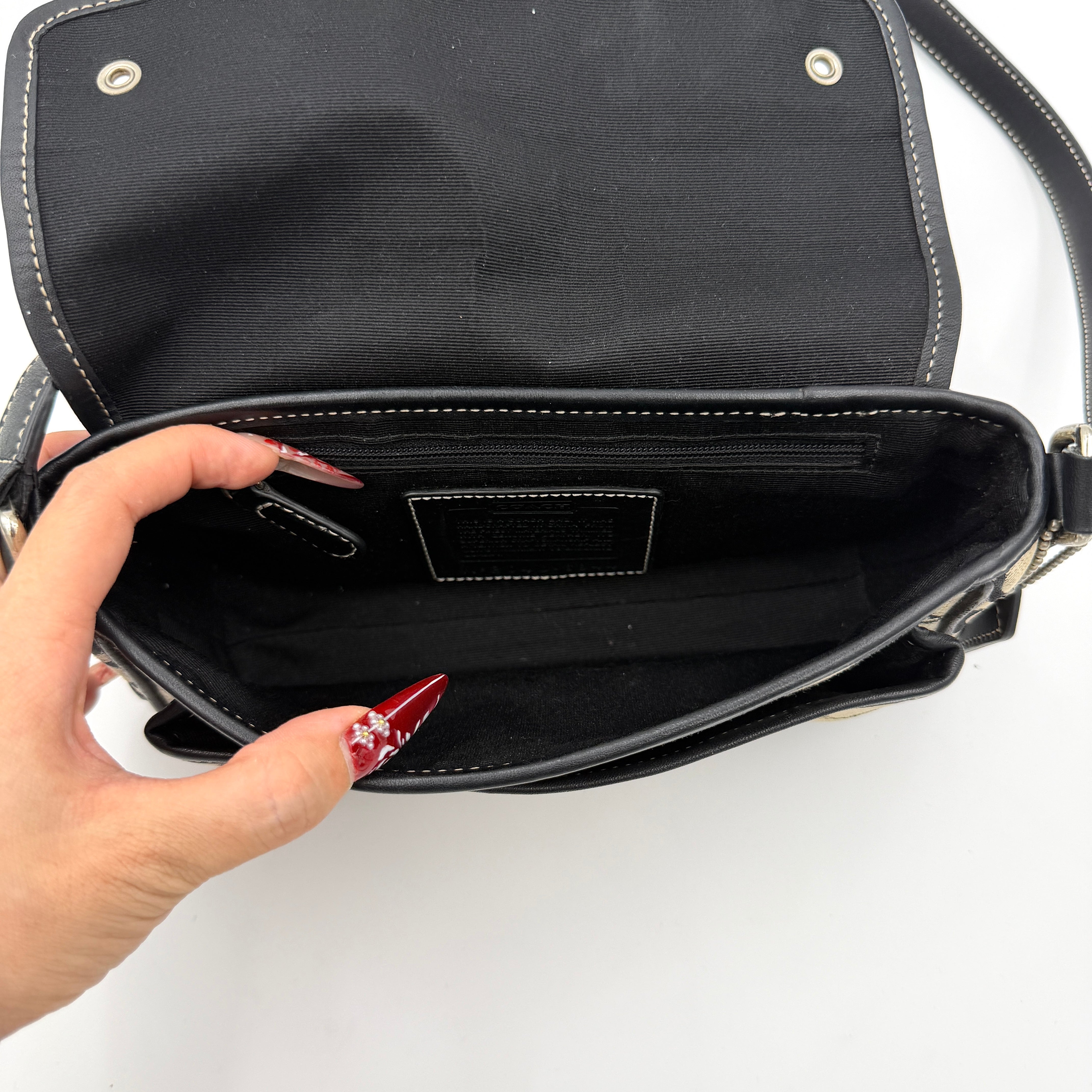 Coach Signature Double Buckle Crossbody bag in grey and black jacquard canvas, accented with black leather trim and dual silver-tone buckle detailing.