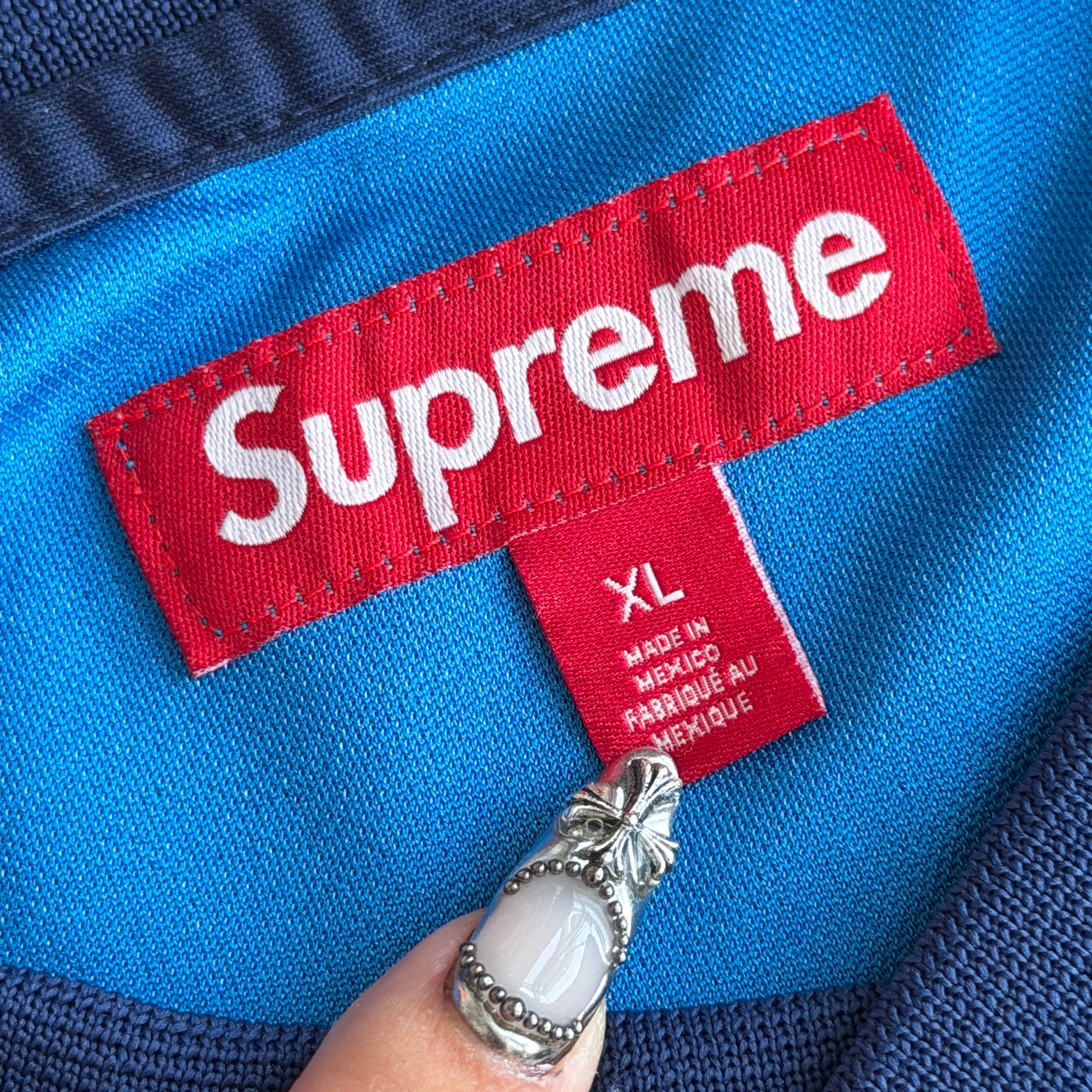 Supreme Jacquard Soccer Jersey in blue with front Supreme script and patch, navy side panels, and sporty detailing.