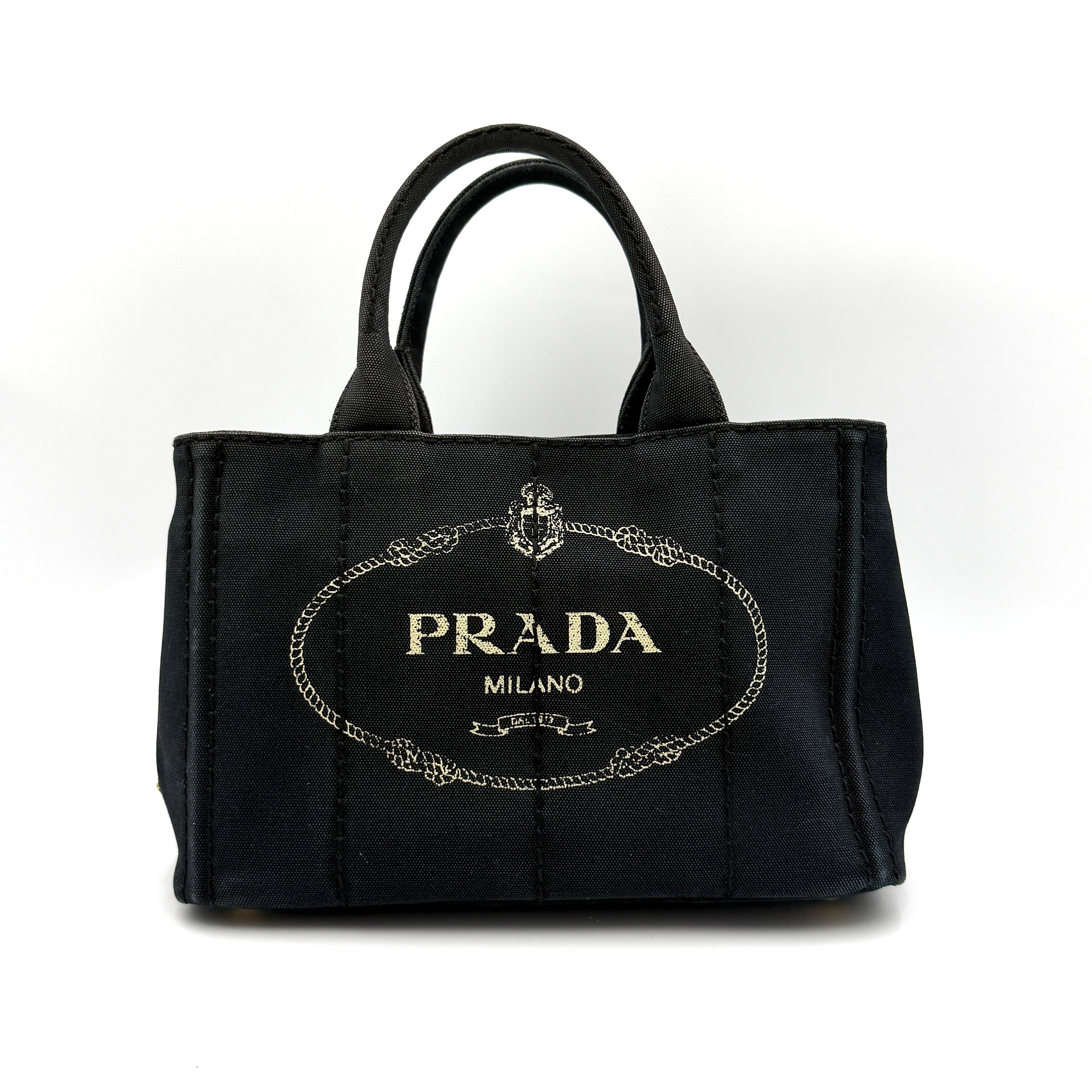 Front-facing Prada Canapa Embroidered Logo Tote in black canvas with ivory stitched logo and double handles.