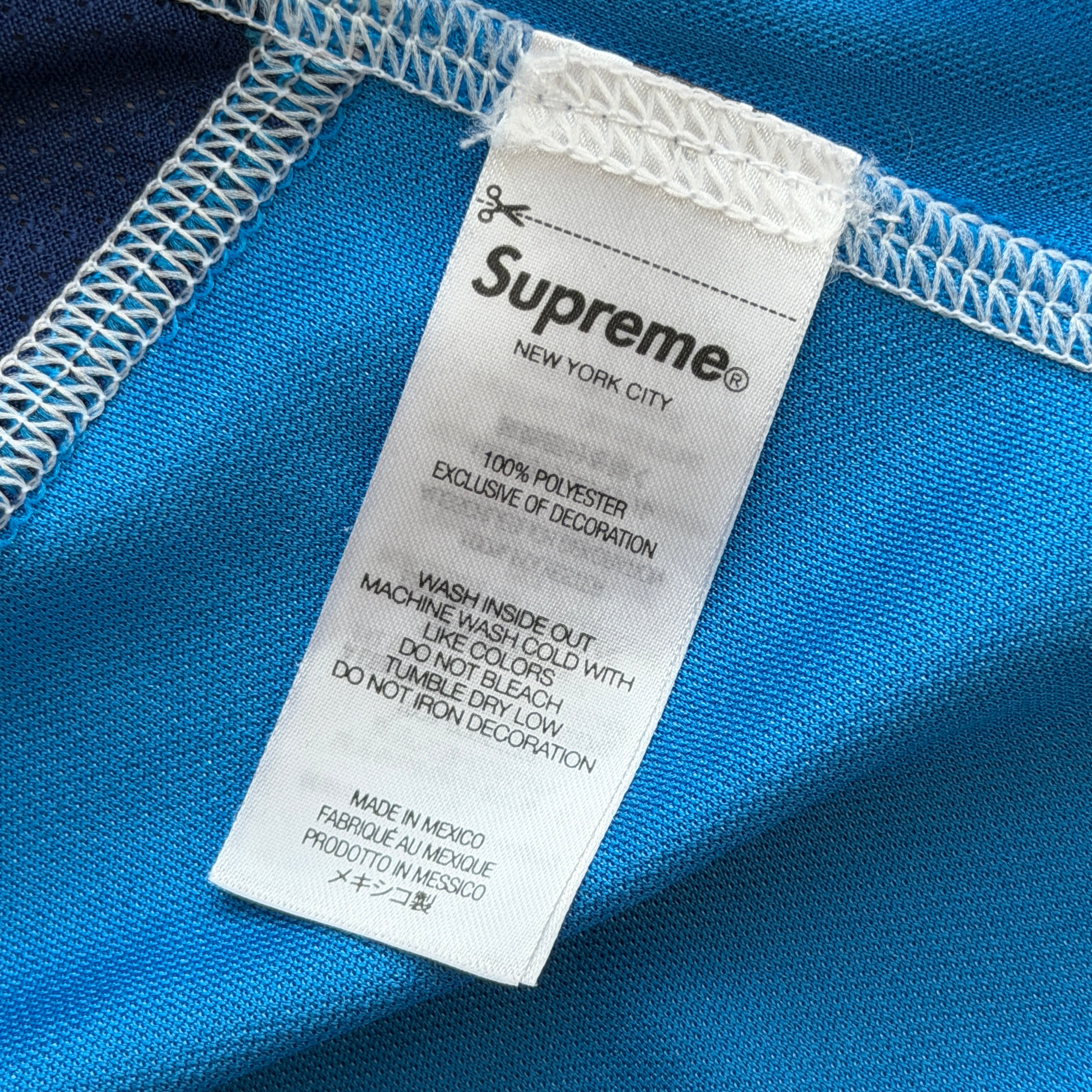 Supreme Jacquard Soccer Jersey in blue with front Supreme script and patch, navy side panels, and sporty detailing.