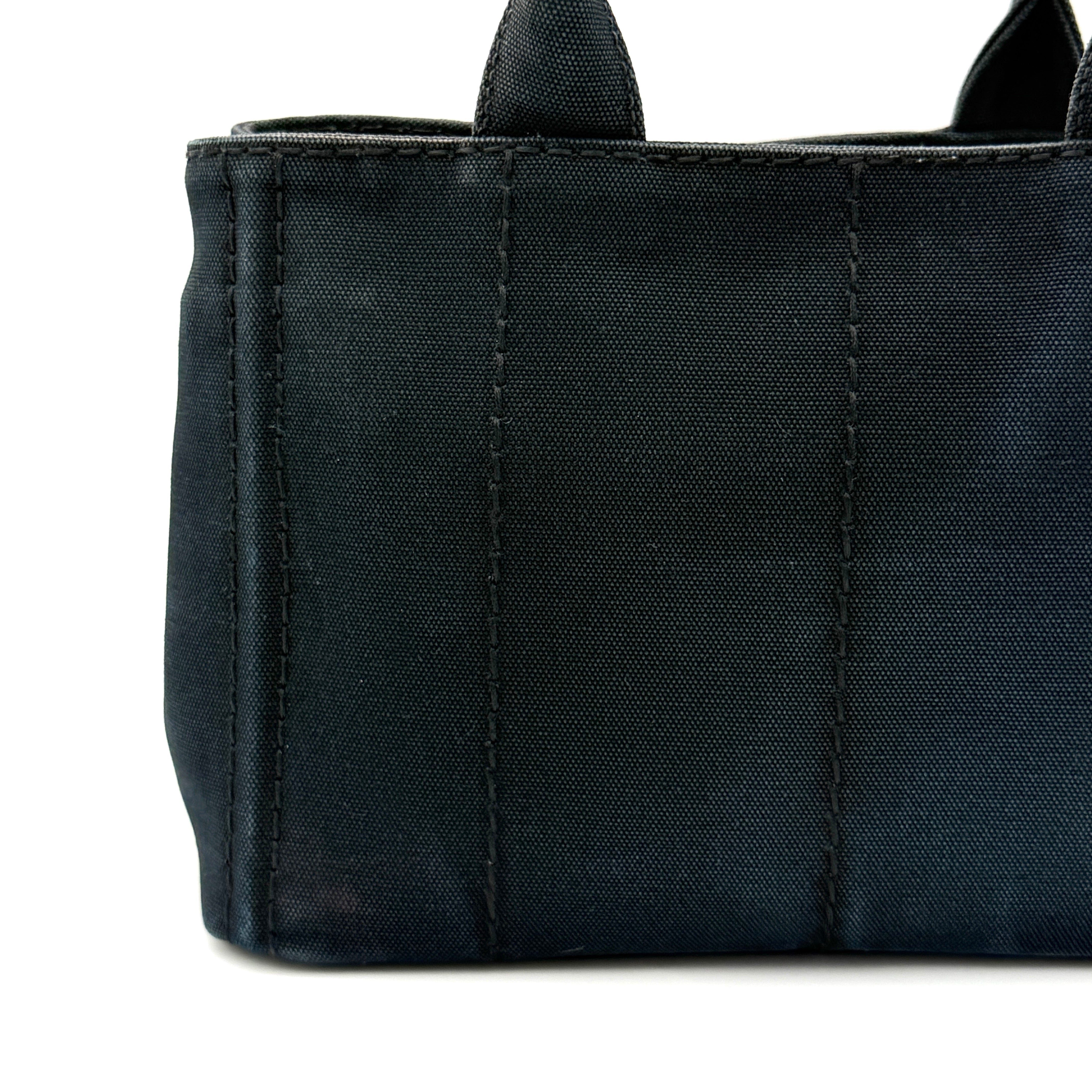 Front-facing Prada Canapa Embroidered Logo Tote in black canvas with ivory stitched logo and double handles.