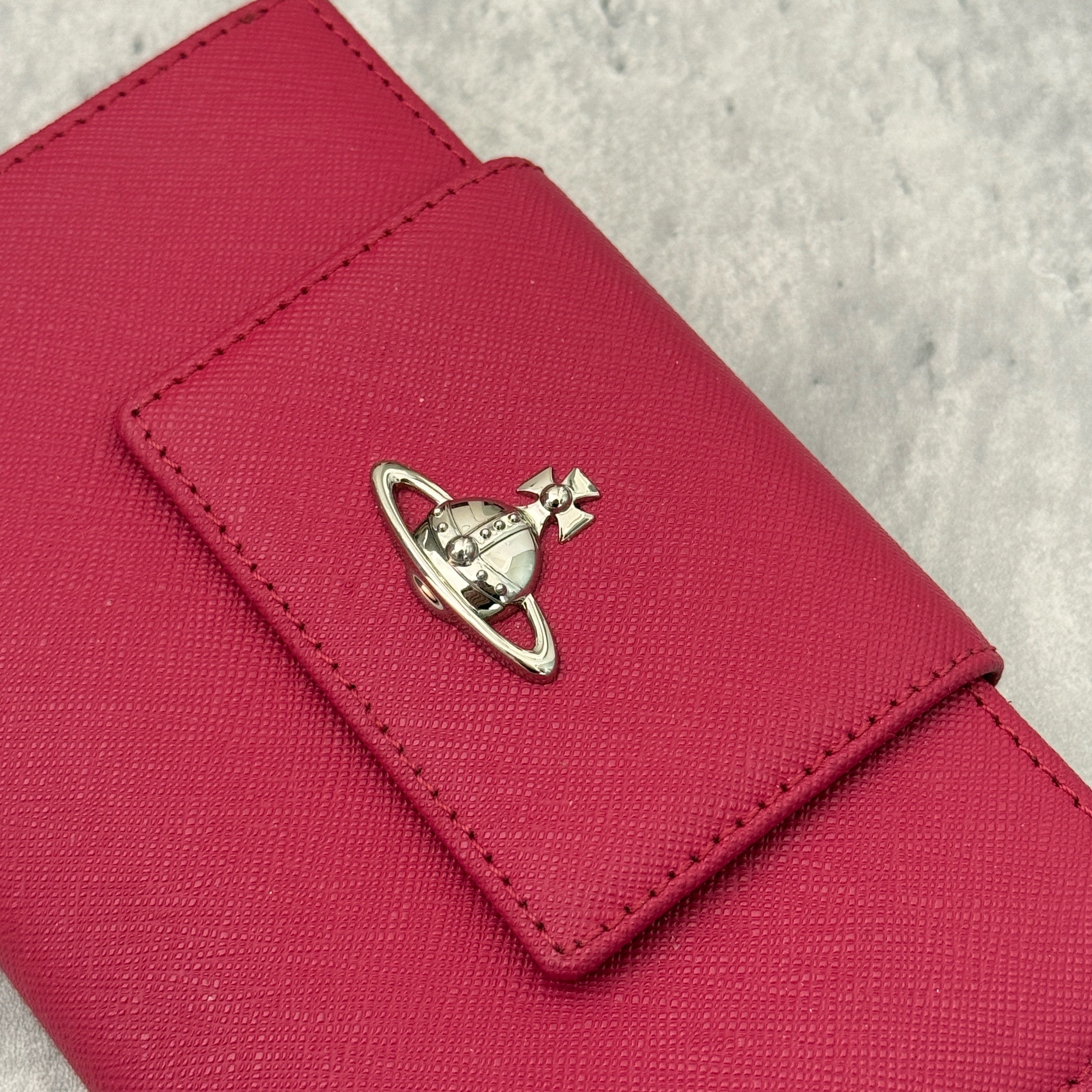Vivienne Westwood Logo Orb Clip Wallet in Rose Pink Saffiano Leather with silver-tone emblem, card slots, and zippered coin pouch.